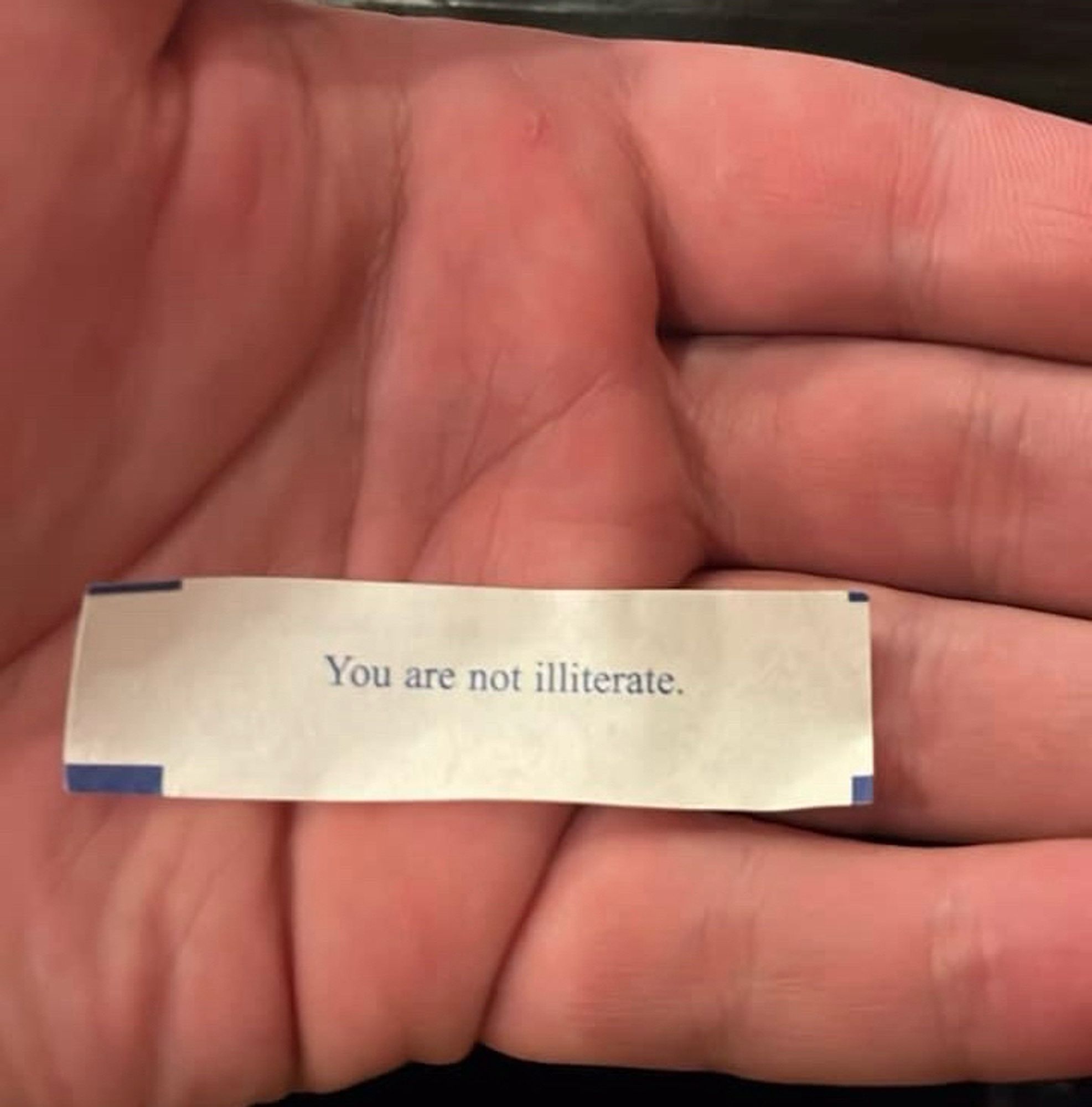 A fortune from a fortune cookie that reads “you are not illiterate”