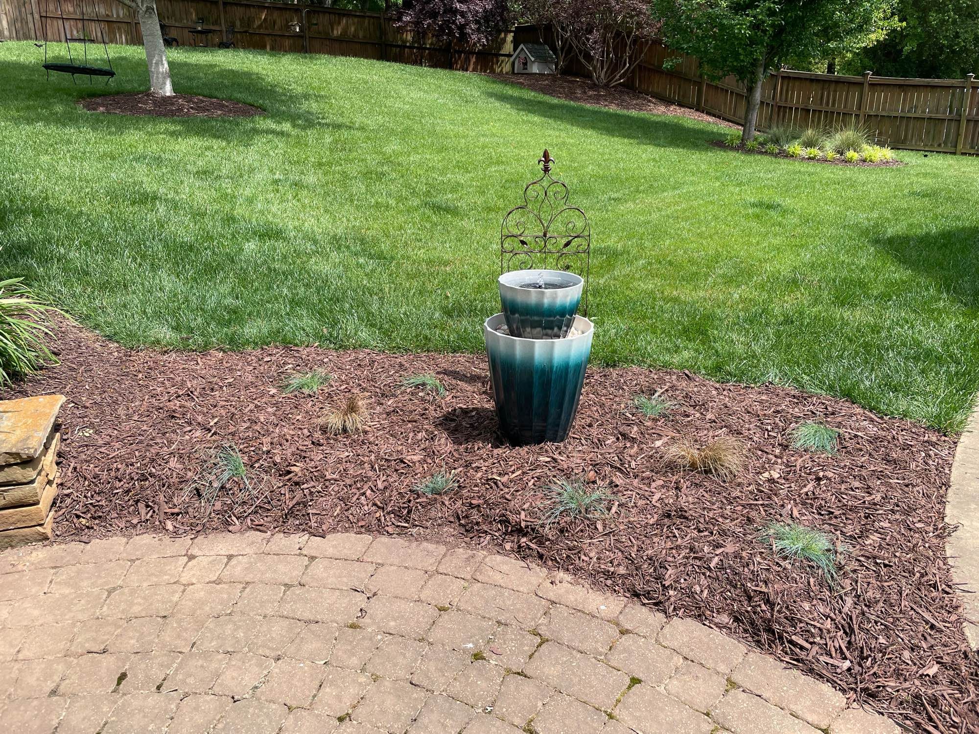 Small fountain in a yard. It’s made from two flower pots and a solar fountain insert.