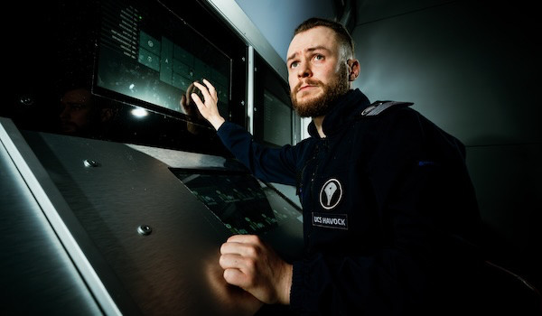 a male figure stood at a spaceship screen