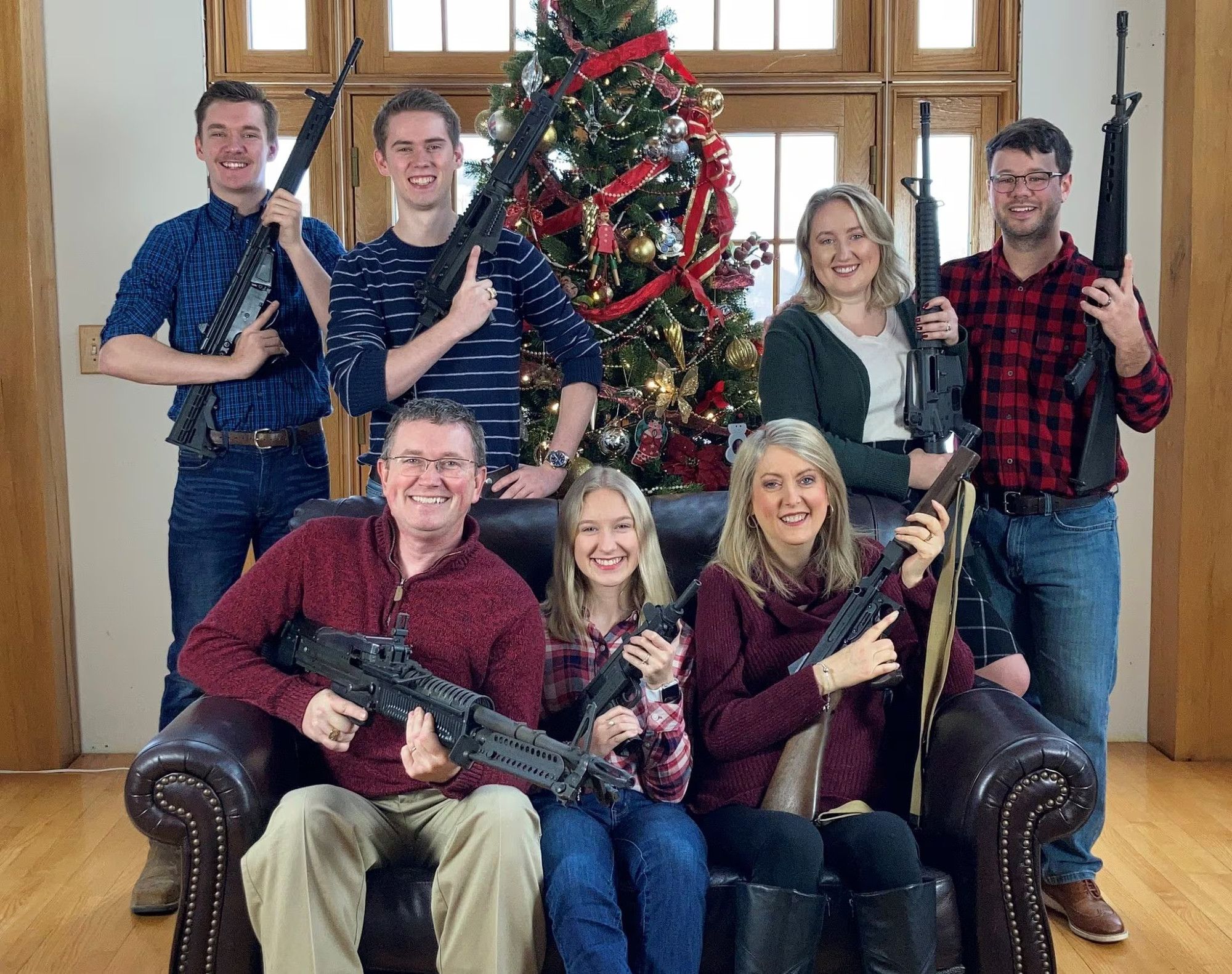 Thomas Massie and family taking a Christmas card photo with them all holding guns. This was sent out days after the Oxford High School shooting.