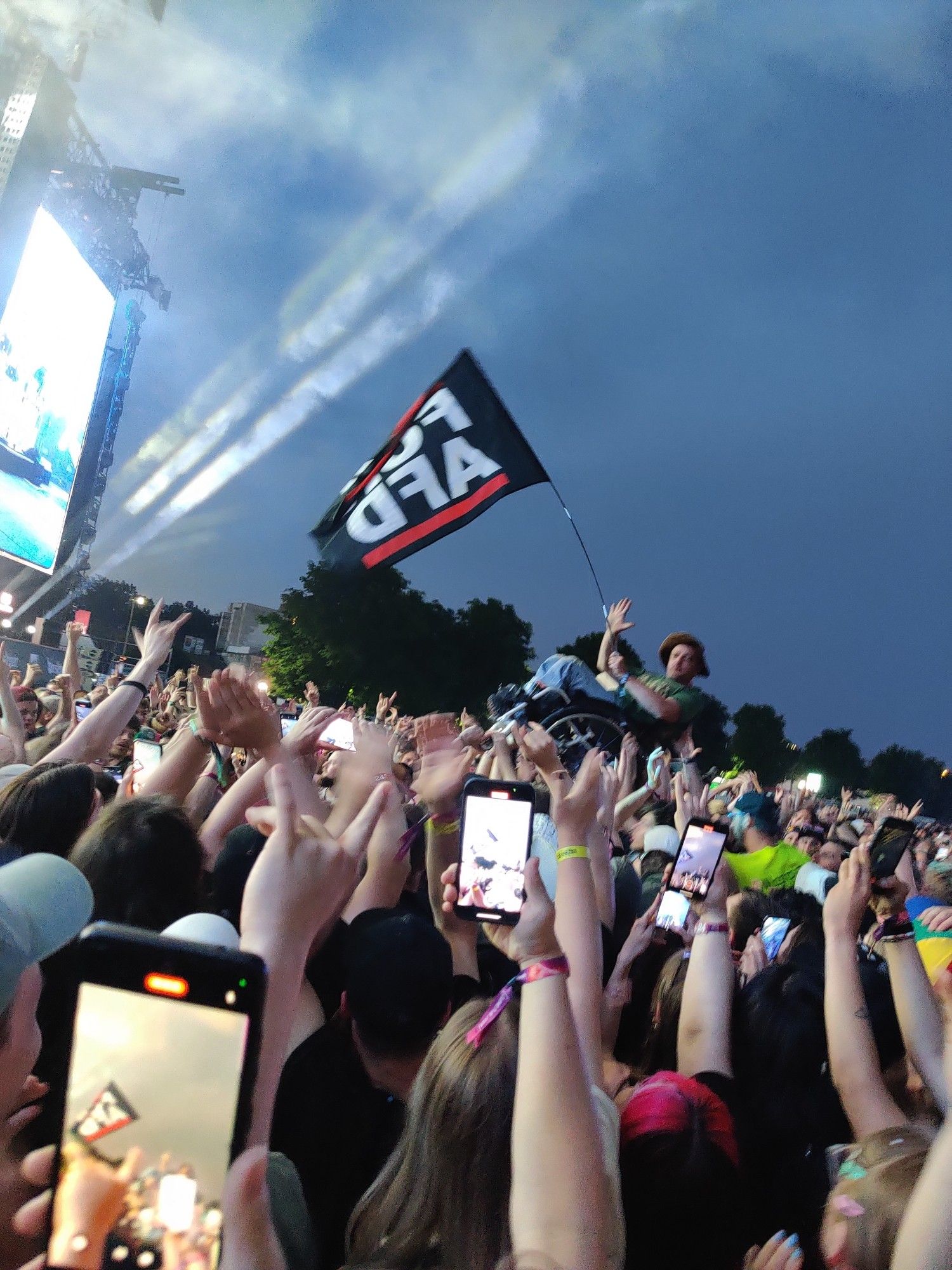 Rolli Fahrer wird crowdsurfend durch die Festivalmenge getragen und wedelt mit FCKAFD Fahne