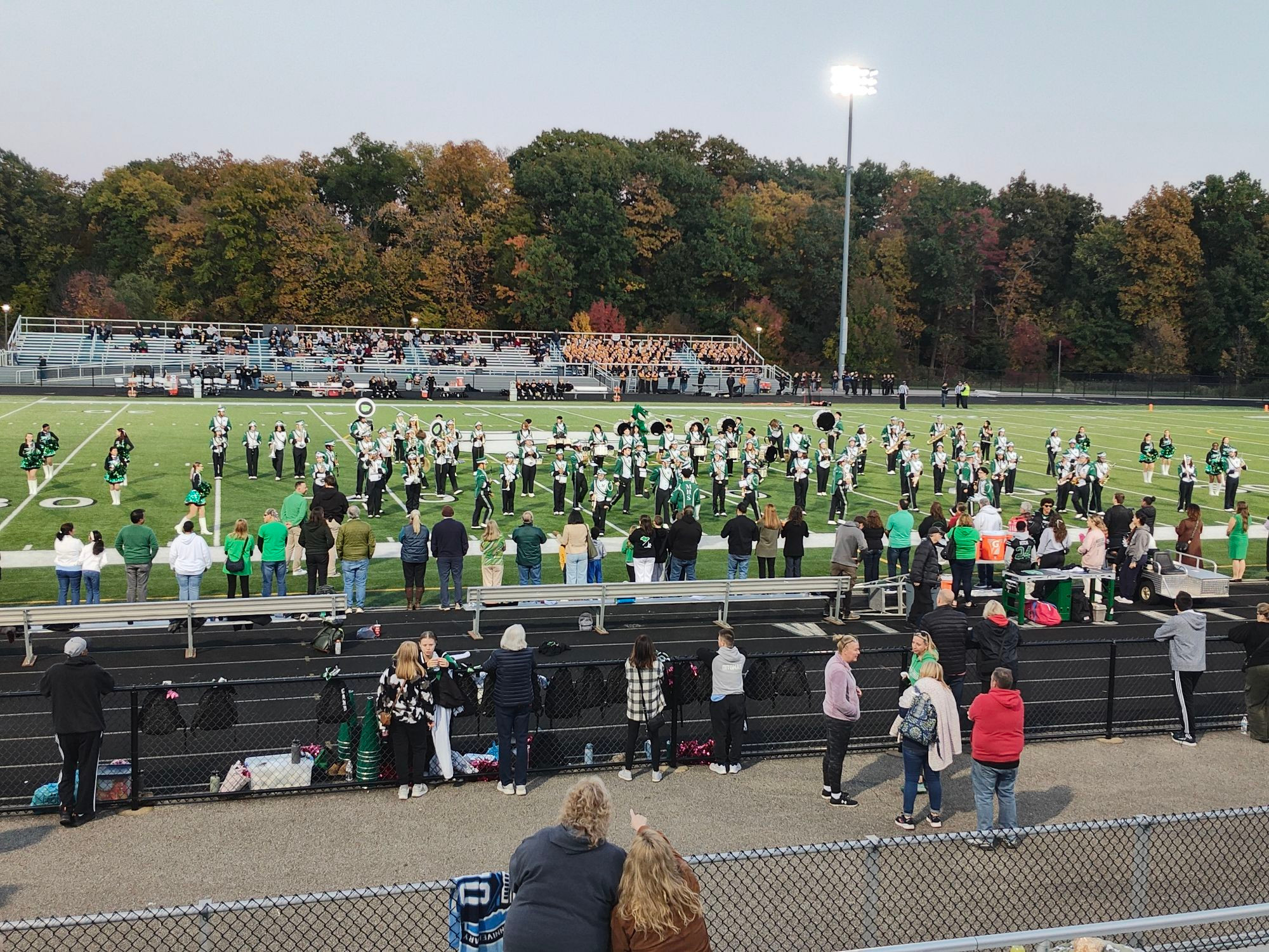 The marching band for Mayfield High School, wearing their green and white uniforms, in formation.