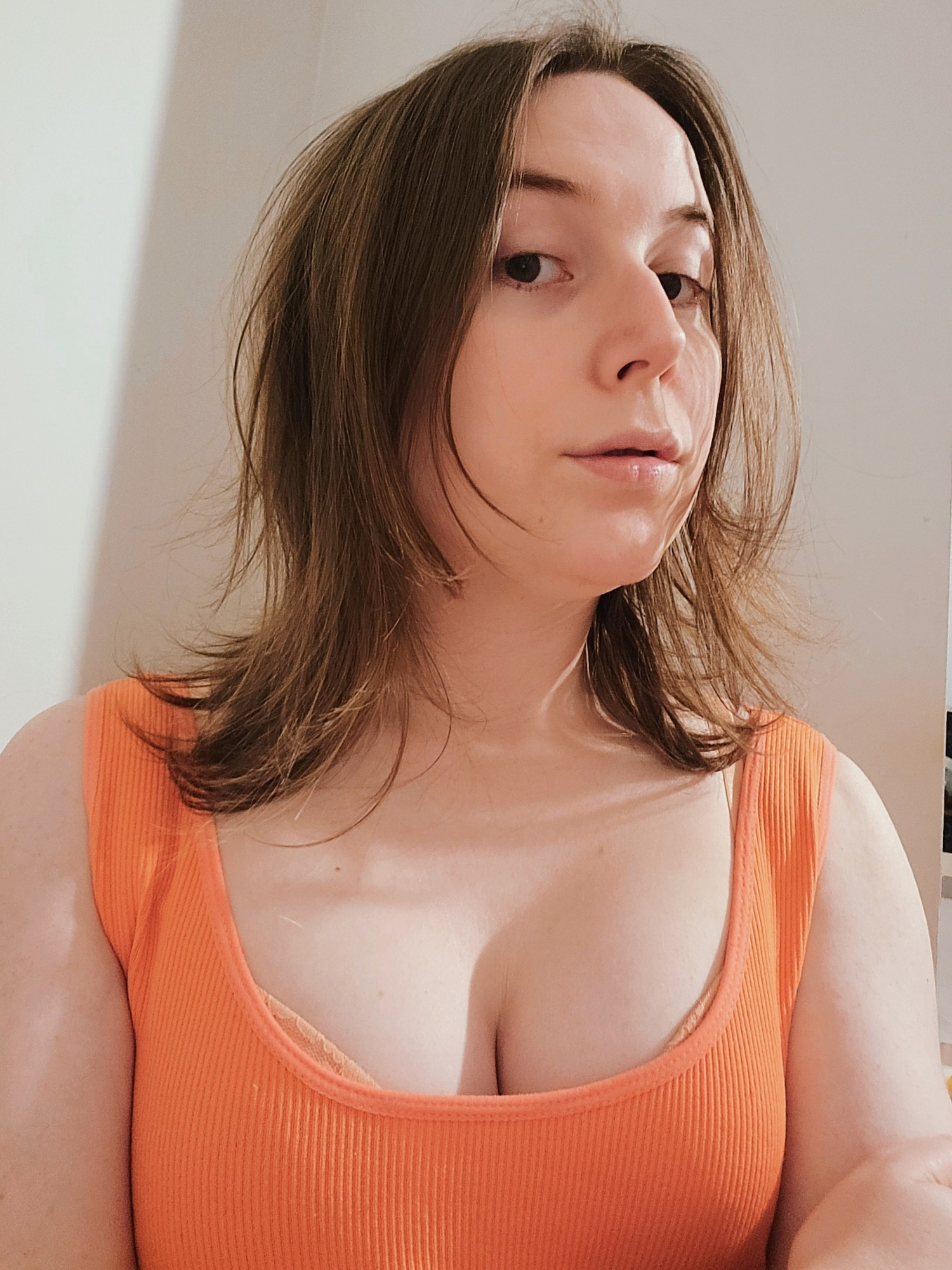 Selfie of Revy 
No make up
Wearing a orange singlet
You can see her bust is bigger lately