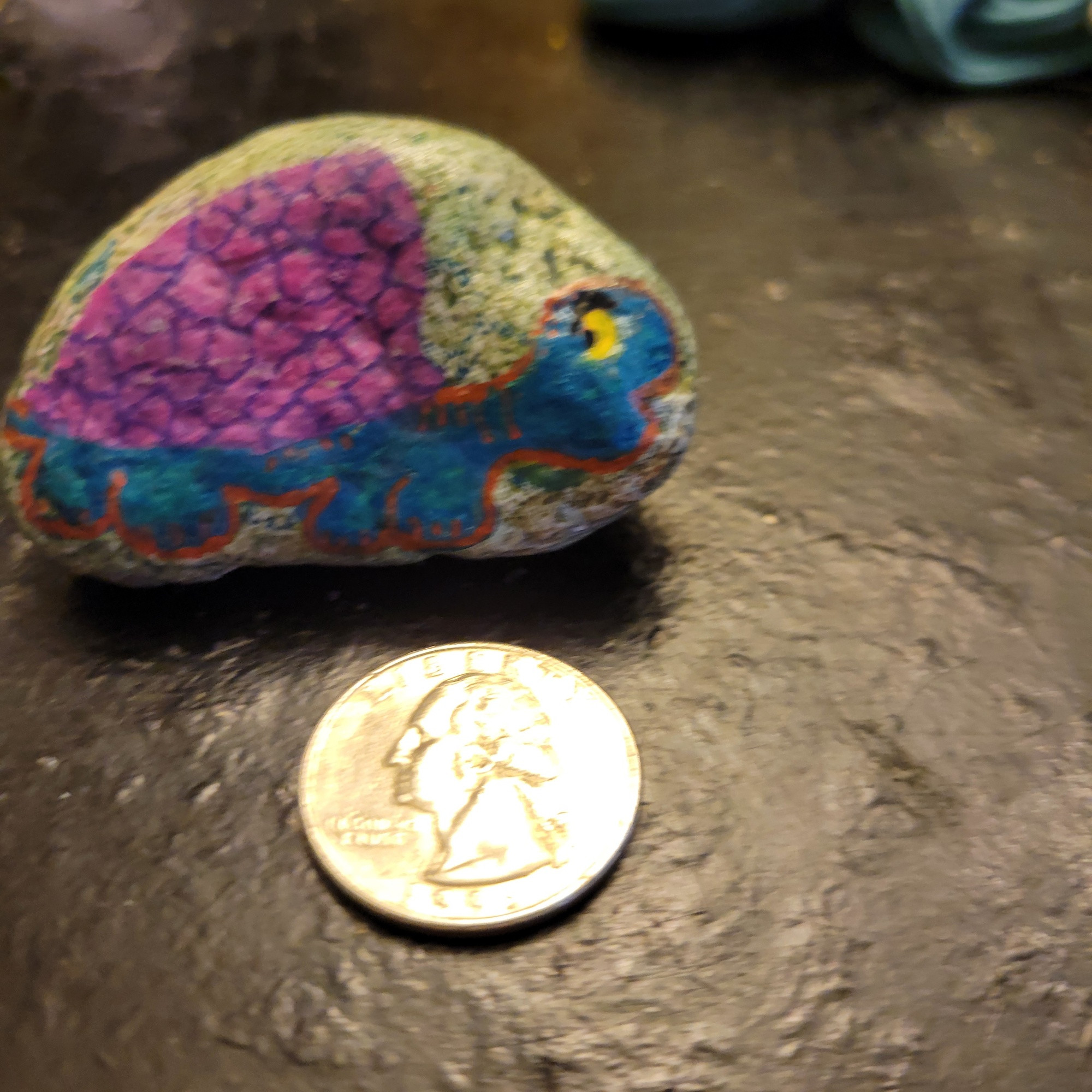 The rock is about 2x1" with a flat bottom side & a curved top edge. There's a green watercolor background. 

I drew a side view of a turquoise turtle (a turquoitle? Is that anything?) with a pink shell divided by purple line segments. The turtle's body is outlined in orange. It has a yellow eye and a prominent black eyebrow. 

Seriously, there's been a lot of similarly shaped rocks over the years and even though some of them turn into snails, an alarming number of rocks that have a curvy top & a flattish bottom will end up as turtles. I just like how the curve of the shell follows the contour of the rock.  

Im stuck on the treadmill for 20 more minutes so OK FINE I'll go find more turtles for you. 




