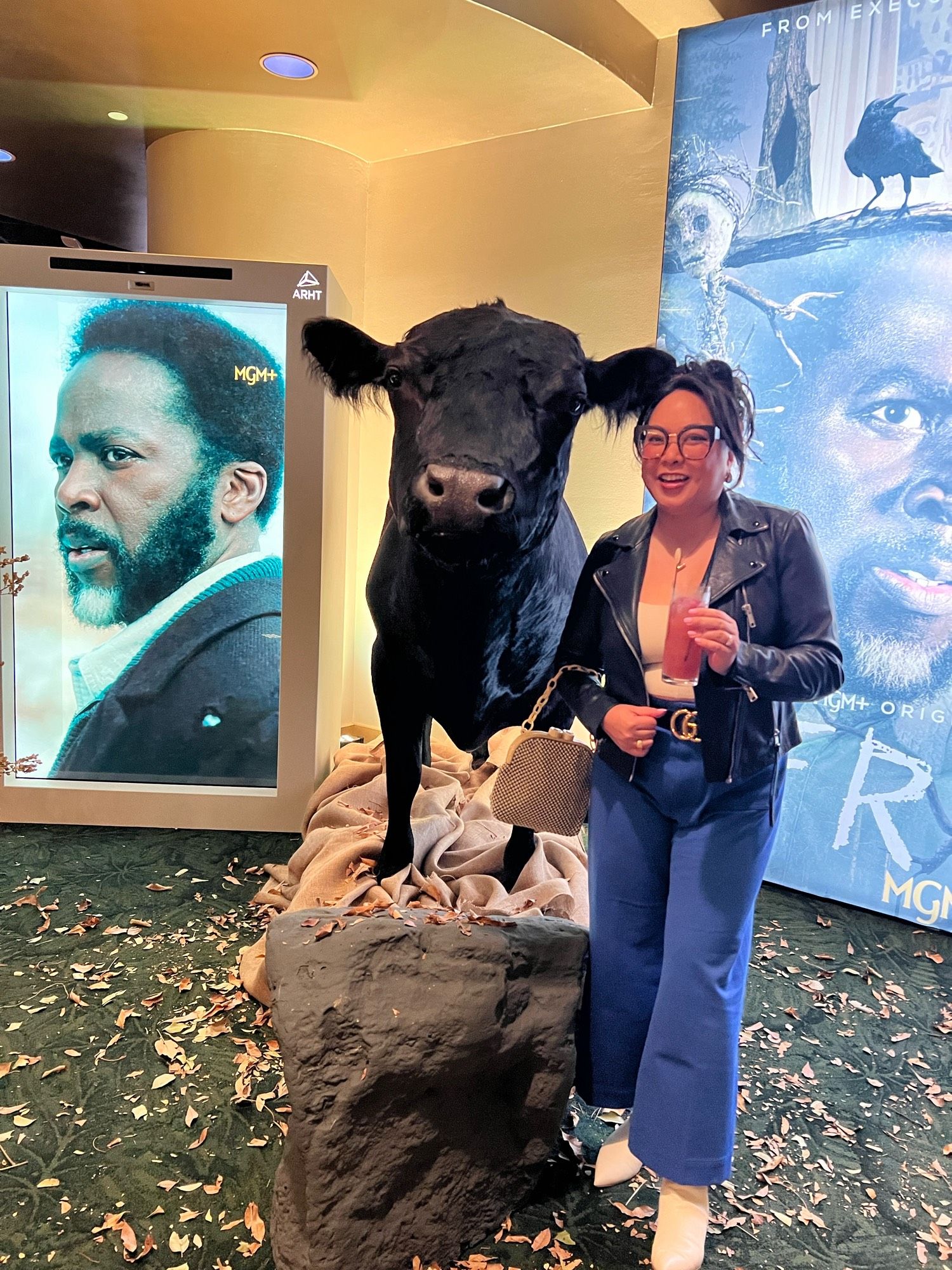 The author in front of a taxidermies cow with the posters from mgm+ show FROM