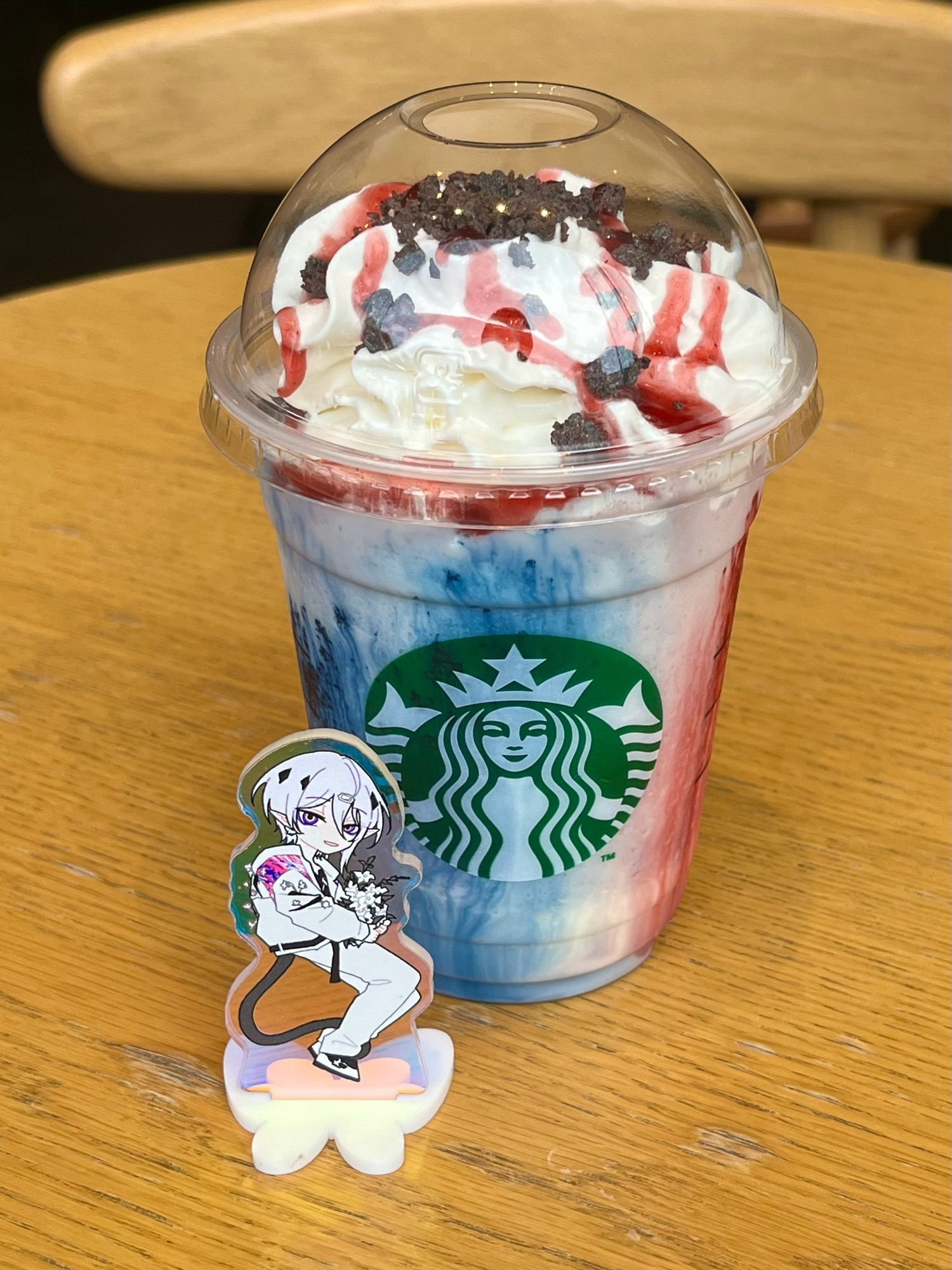 スターバックスのフラペチーノの前にキャラクターのアクリルスタンドが置いてある