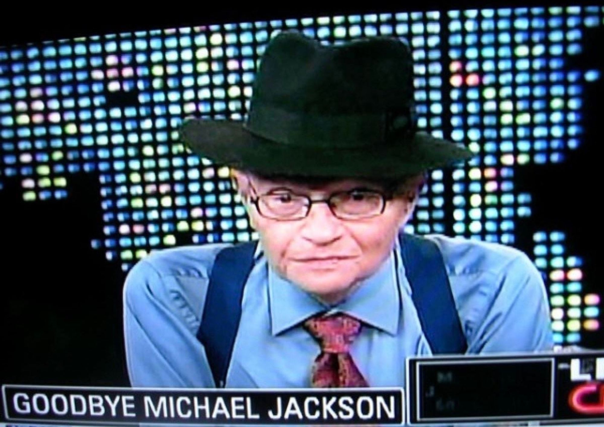 Larry King saying goodbye to Michael Jackson in a black fedora