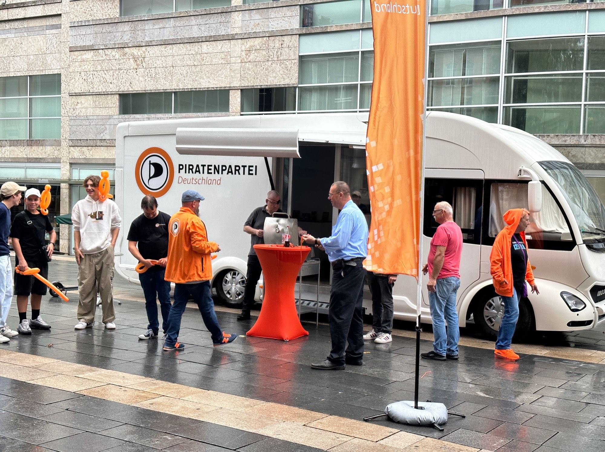 Wahlkampfbus der Piratenpartei Hessen in Wiesbaden mit vielen Menschen davor.