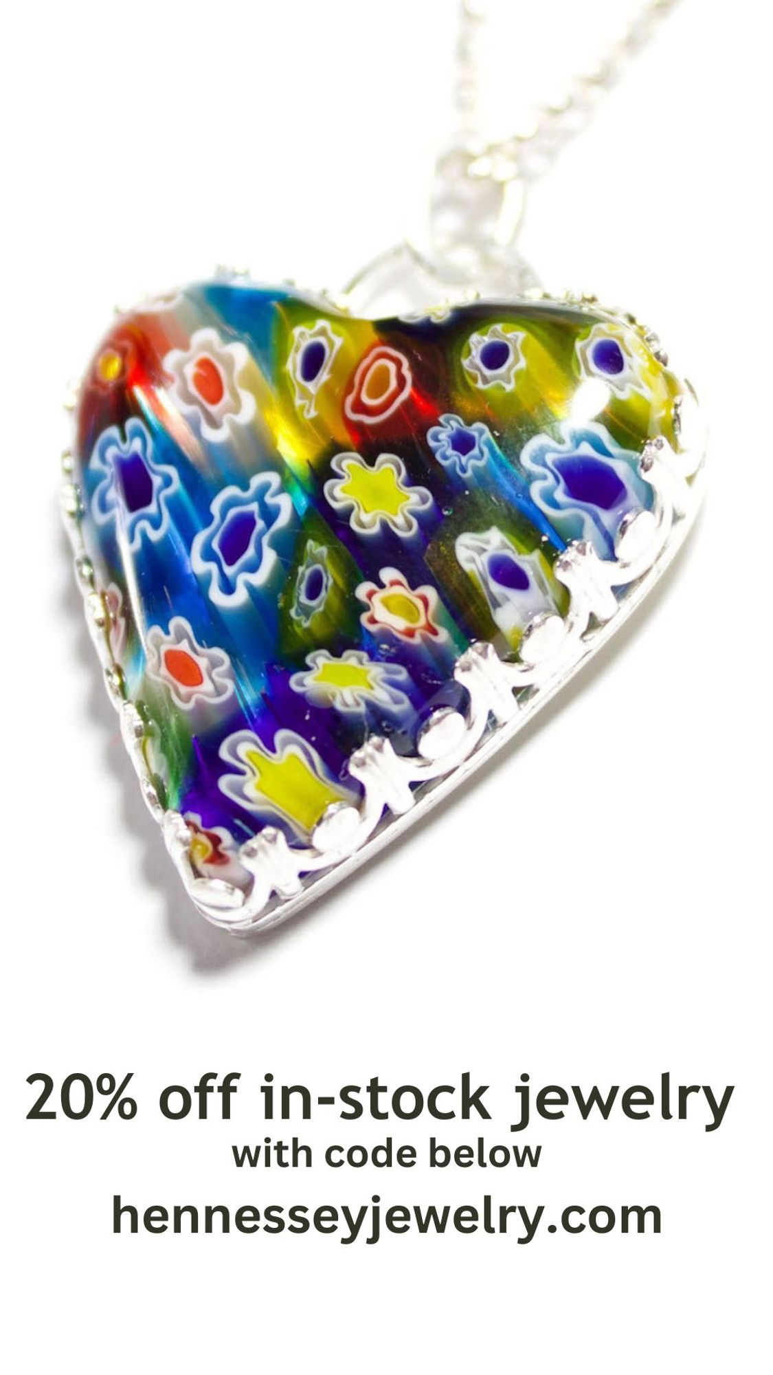 Heart shaped pendant. The heart is millefiore glass with blue, red, orange, and yellow flowers, and the bezel is a fancy wire.