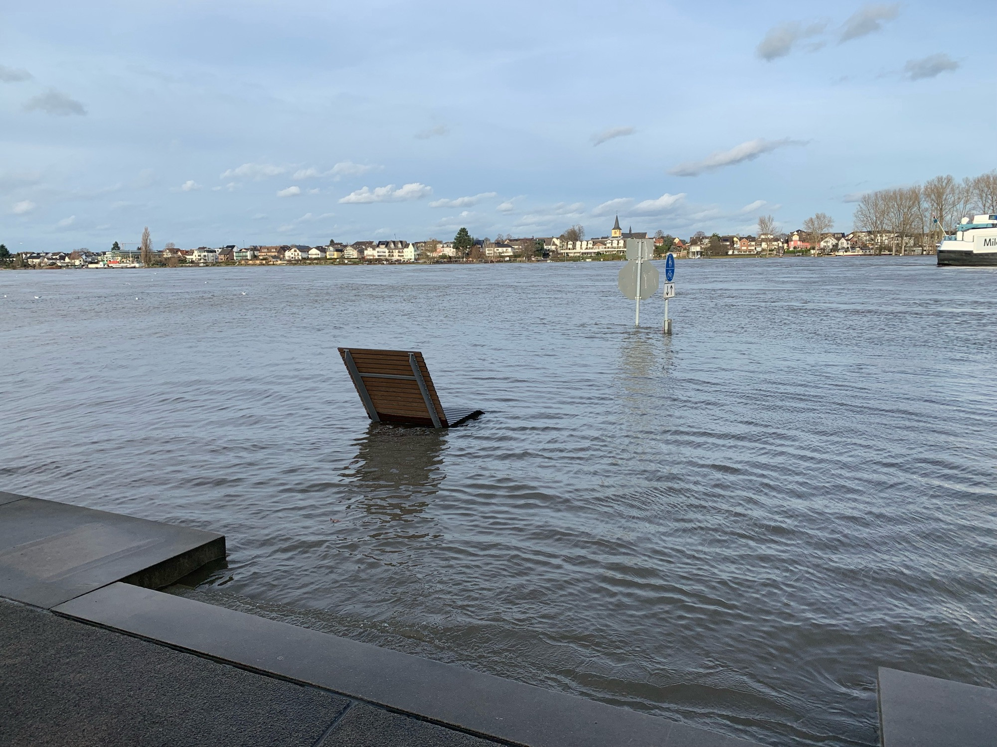 Überschwemmter Uferbereich mit aus dem Wasser ragenden Sitz