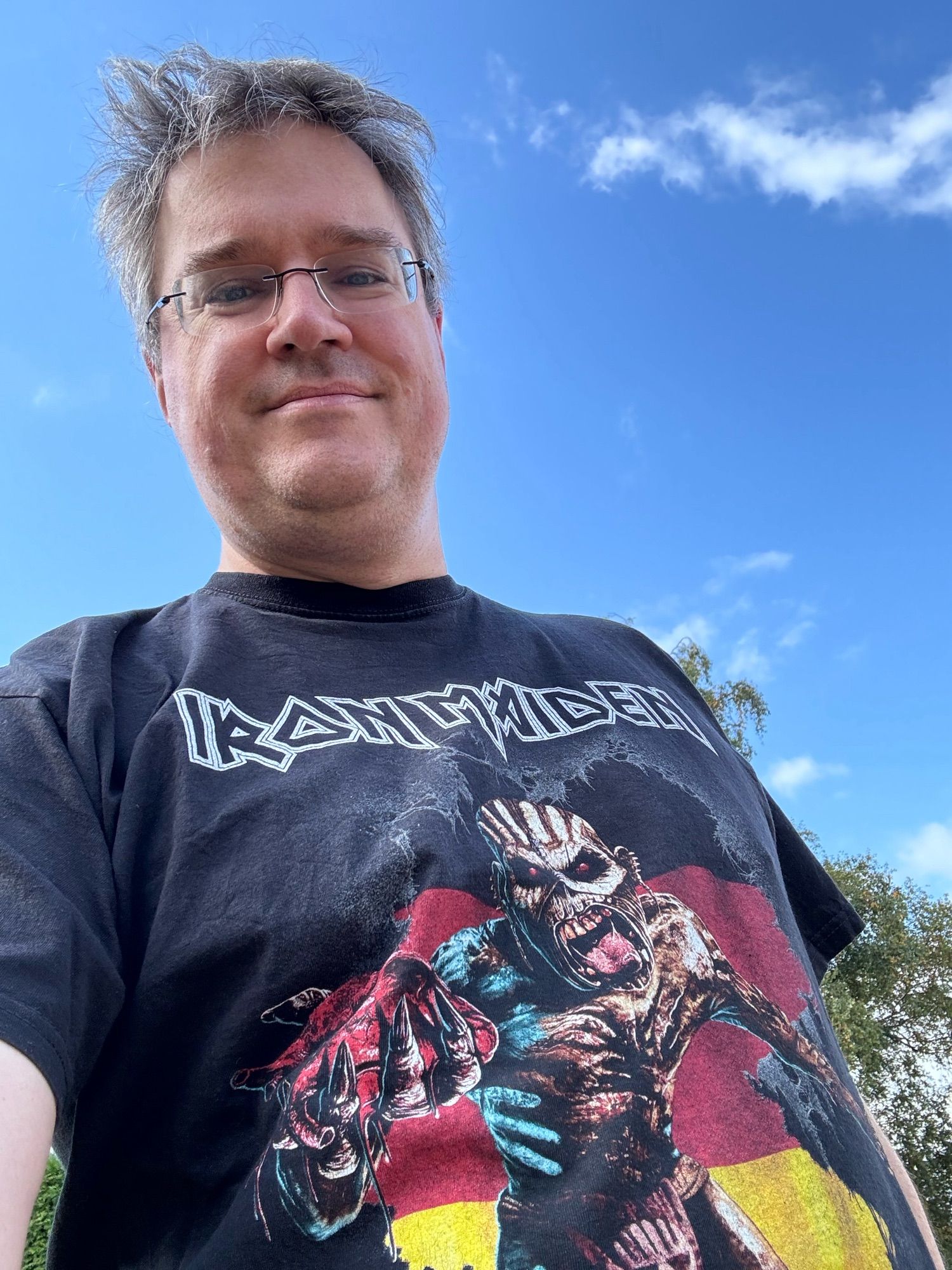 Andreas im "Iron Maiden"-Shirt mit dem Eddie-Monster vor einem schwarz-rot-goldenen Landkartendeutschland