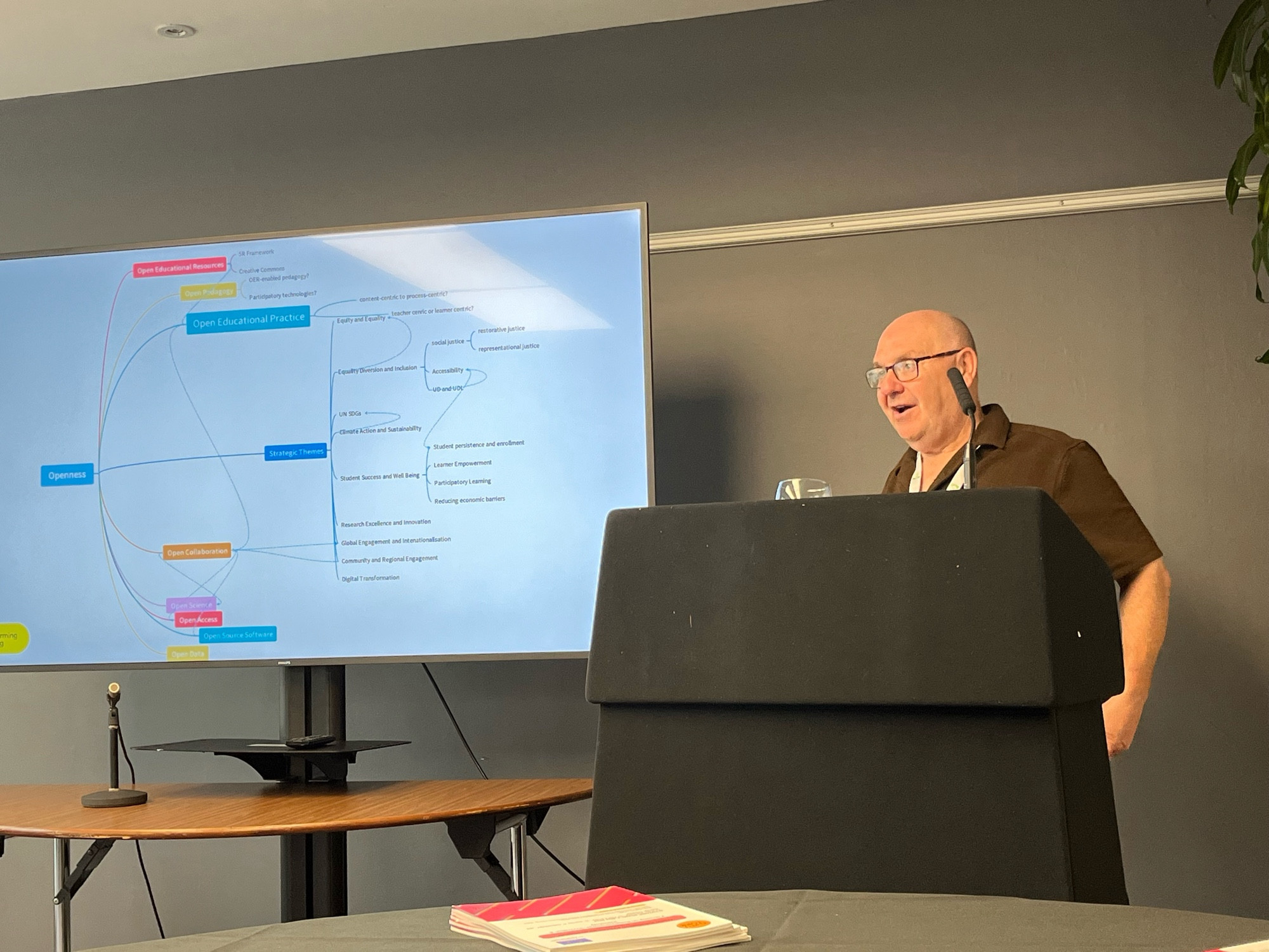 Image of Tom presenting from behind a lectern