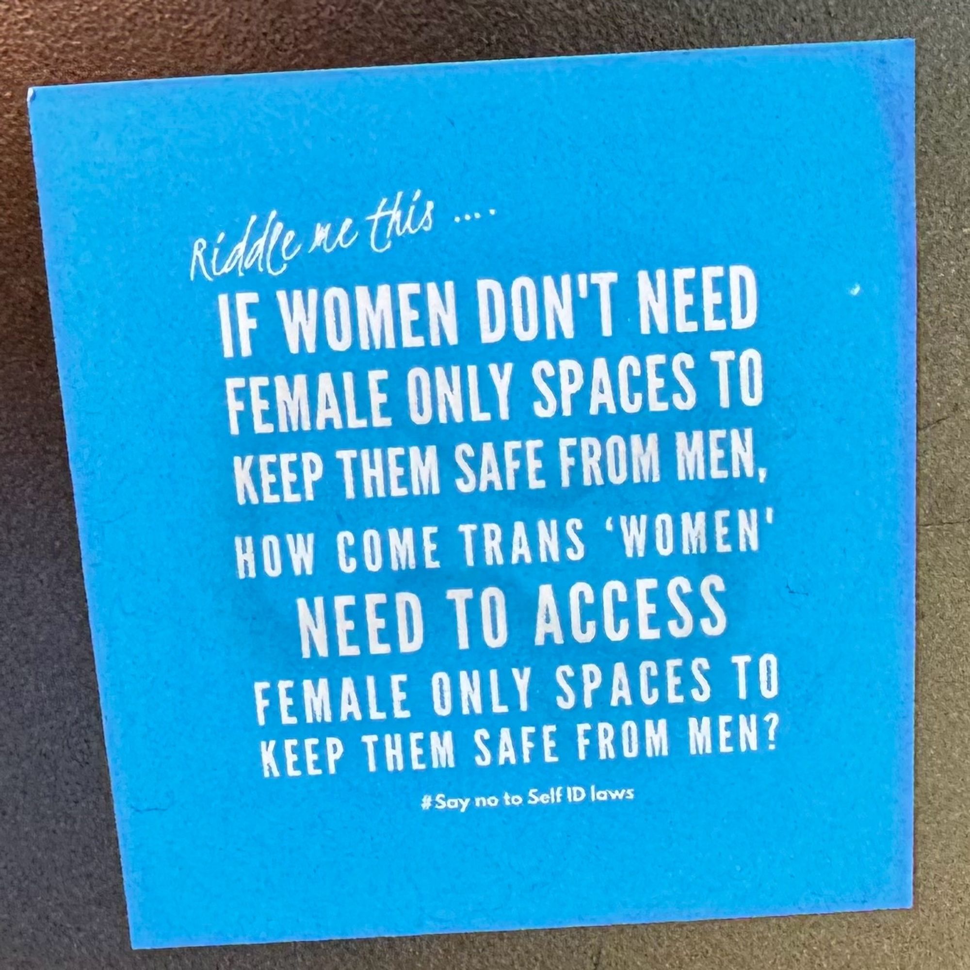 A sticker placed on a bollard that reads:

Riddle me this ...
IF WOMEN DON'T NEED FEMALE ONLY SPACES TO KEEP THEM SAFE FROM MEN, HOW COME TRANS 'WOMEN' NEED TO ACCESS FEMALE ONLY SPACES TO KEEP THEM SAFE FROM MEN?
#Say no to Self ID laws