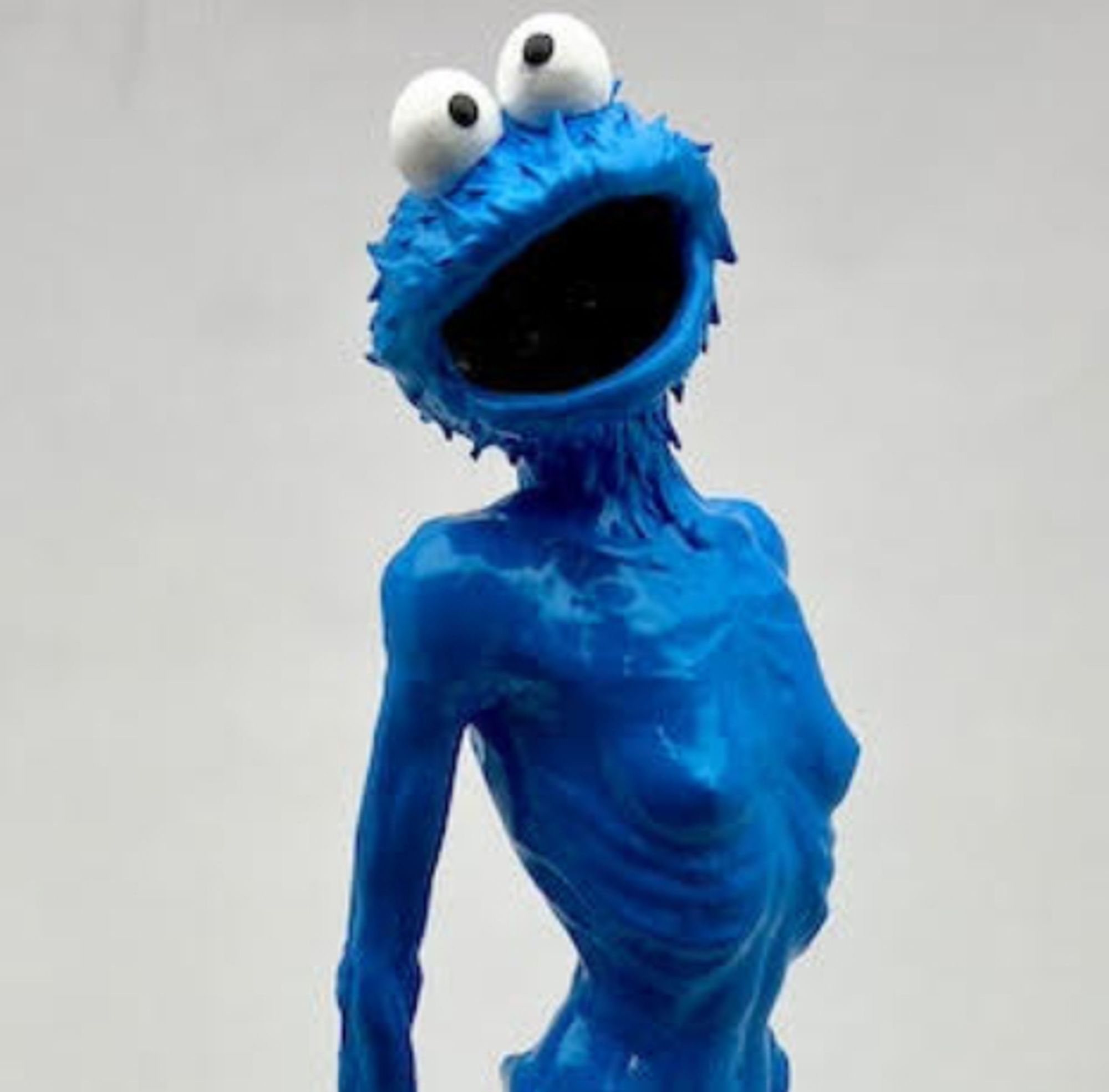 Imagine the cute loveable Sesame Street character Cookie Monster, who is blue and has large eyes and cute fur. Now imagine he has been put on to the naked body of an emaciated woman, also blue.