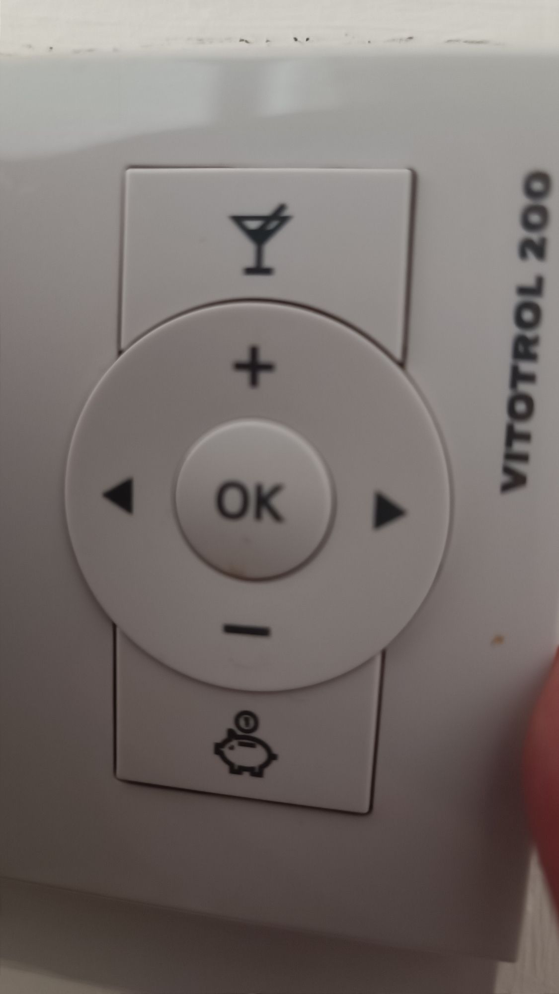 A thermostat control panel with an extra button under the minus that shows a piggy bank and a button over the plus button that shows a cocktail