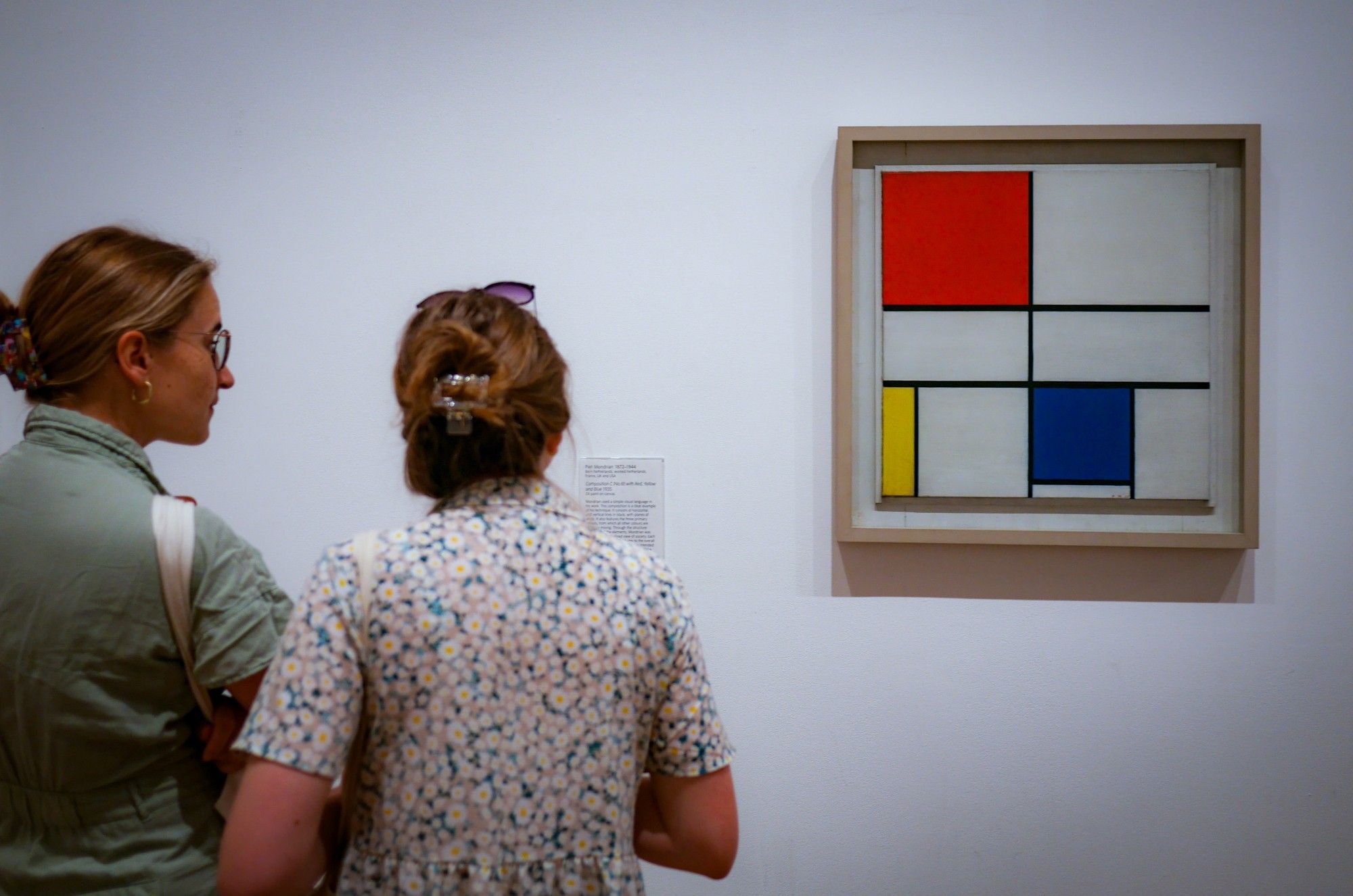 Two people viewing a painting