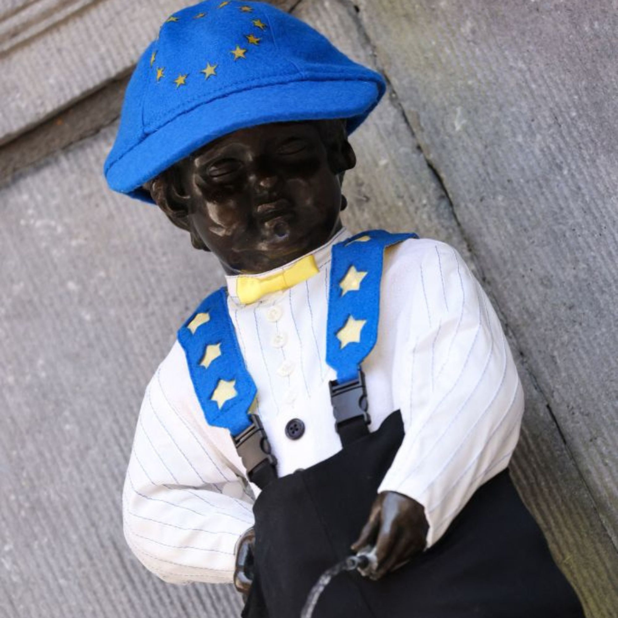 A photo of Manneke Pis dressed in the EU flag and its colors