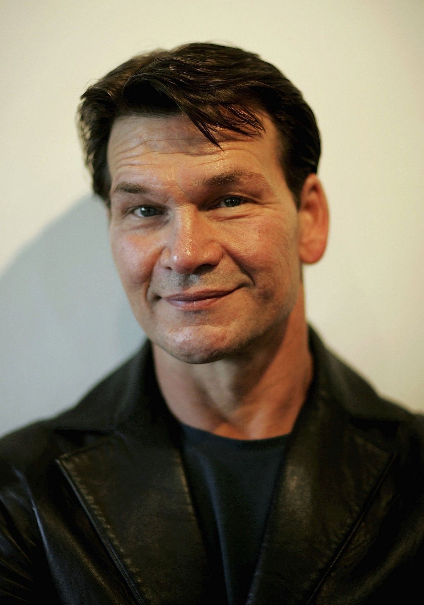 black leather jacket, short brown hair. charming smile. white guy