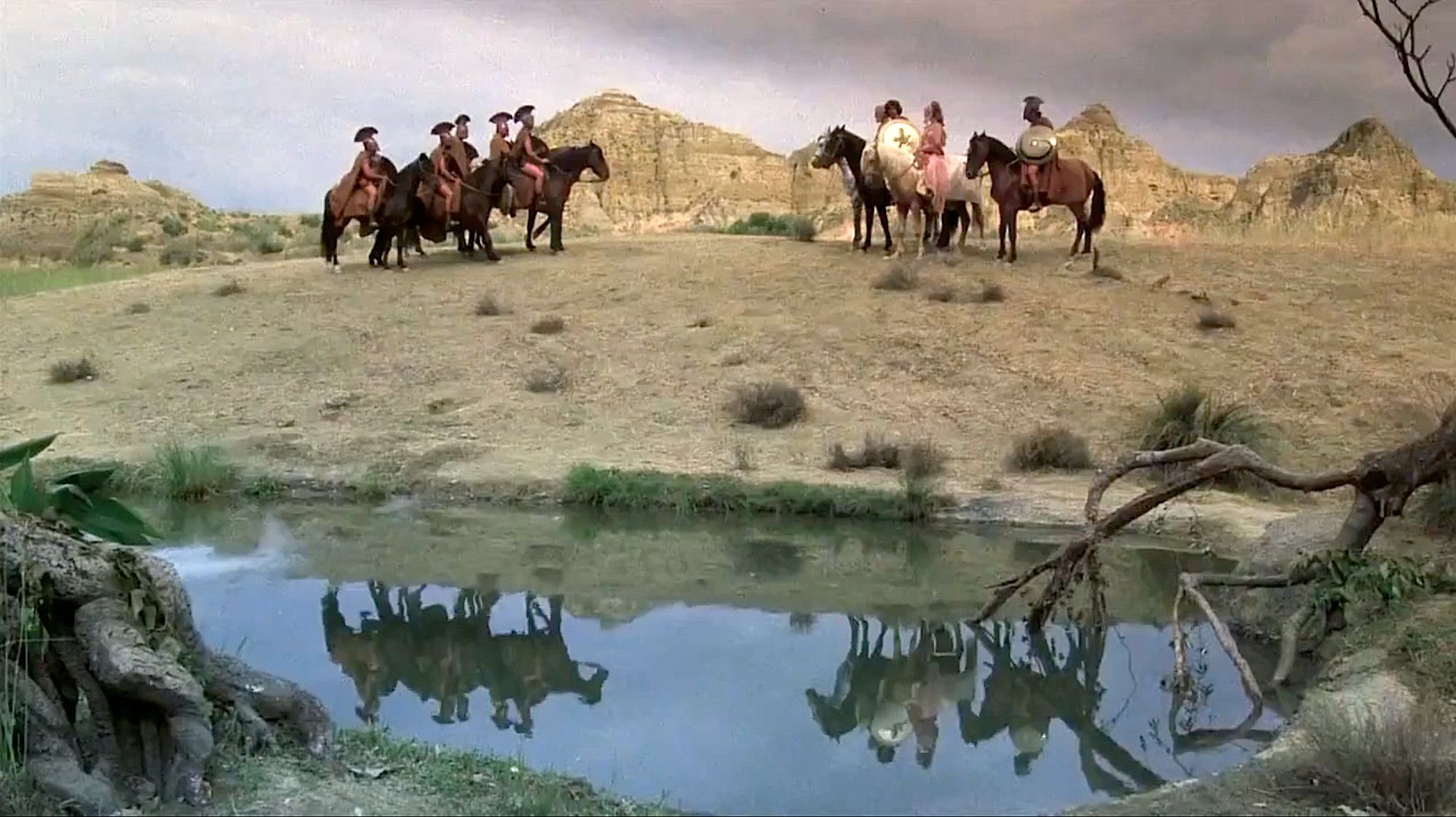 Riders reflecting on a point of water in front of a pretty mountain