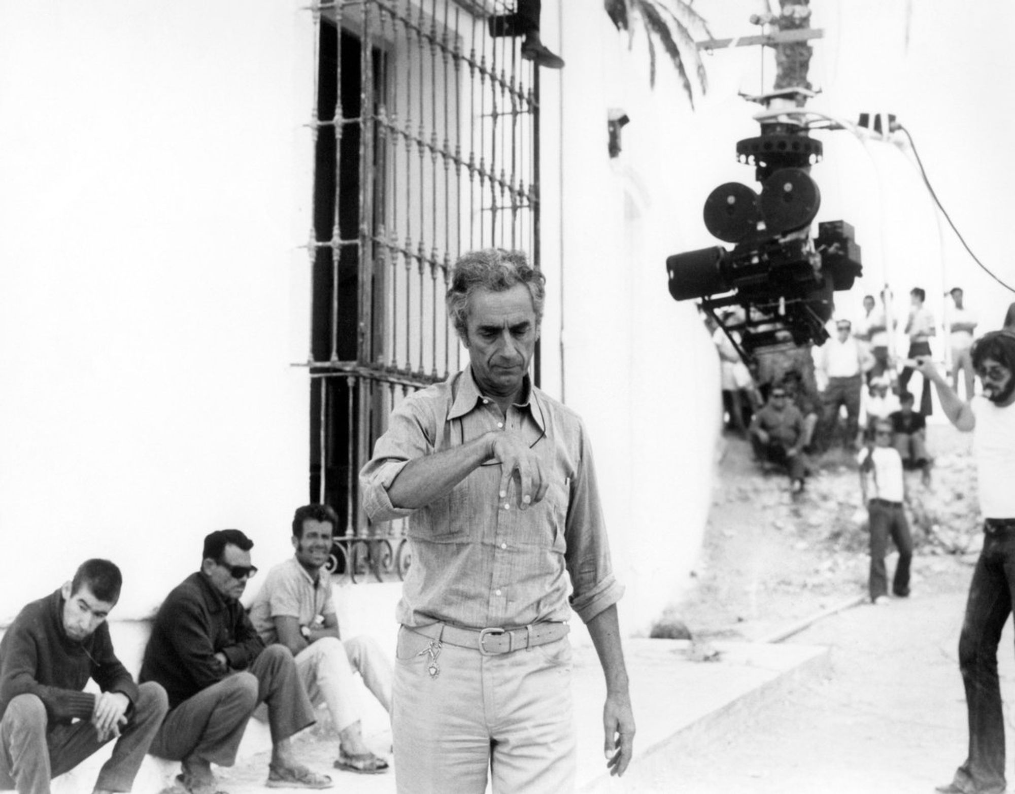 Michelangelo Antonioni walking past the hotel room window in Vera while preparing for filming