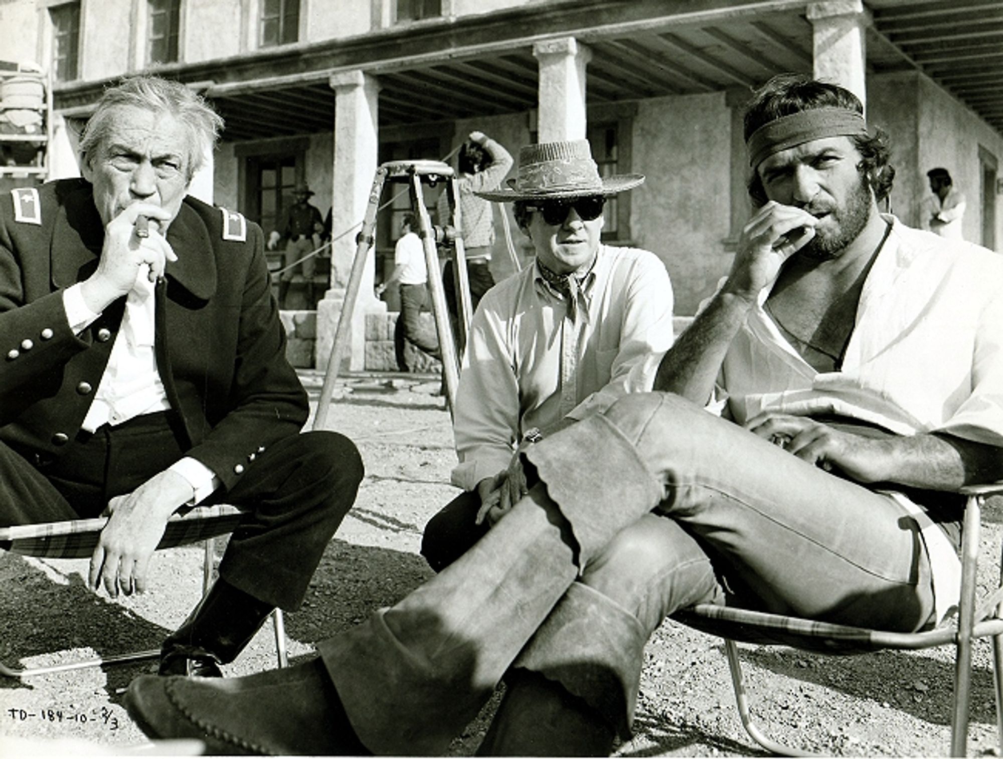 John Houston smoking cigar with Director Burt Kennedy and Bekim Fehmiu on the Fort Bowie cinema set