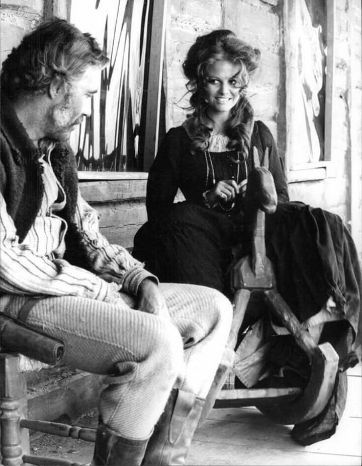 Jason Robards and Claudia Cardinale on the set of “Once Upon a Time in the West", Jason sitting on a chair looks at Claudia sitting on a rocking horse