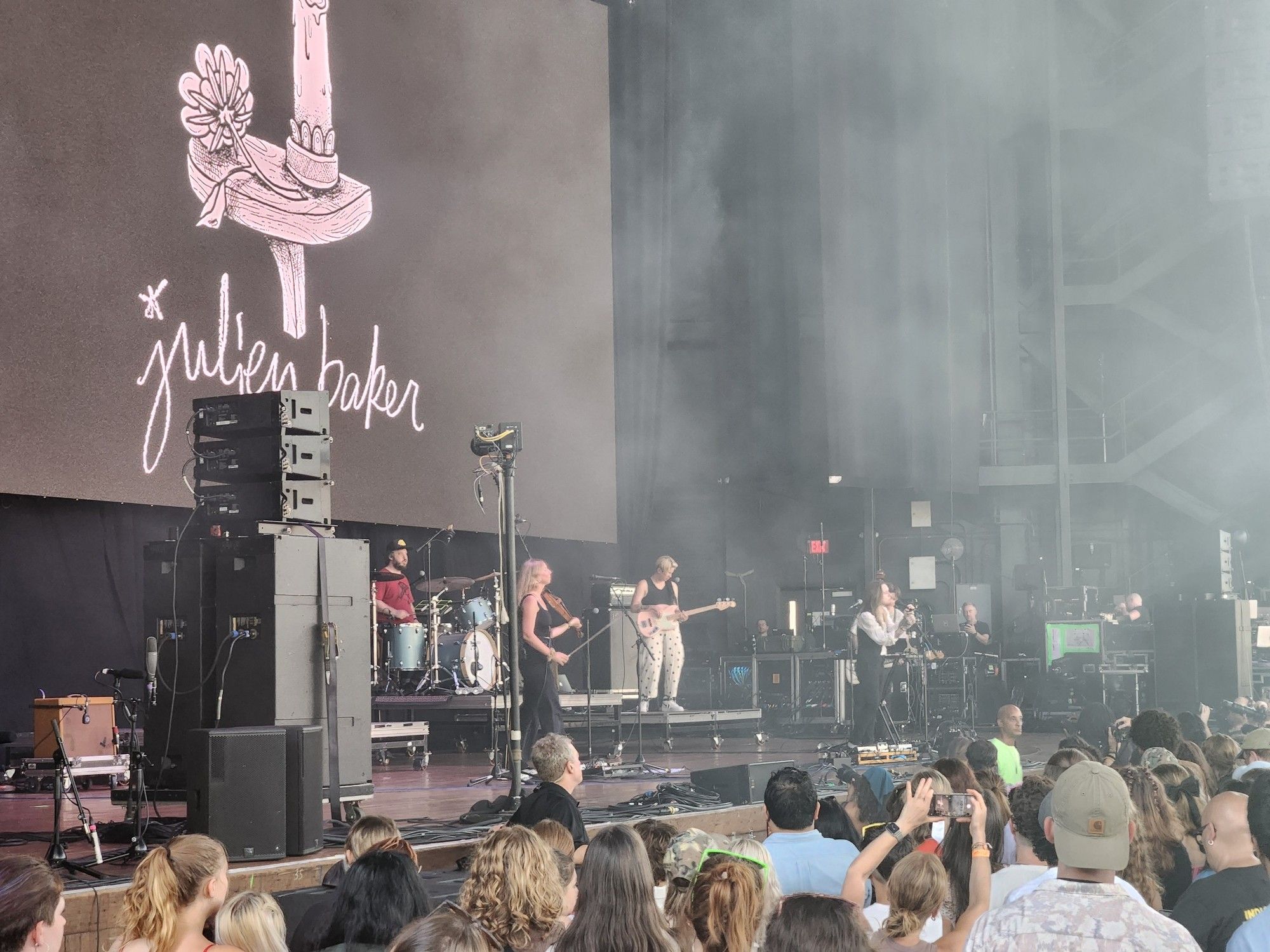 Music band Julien Baker performing on stage in front of crowd.