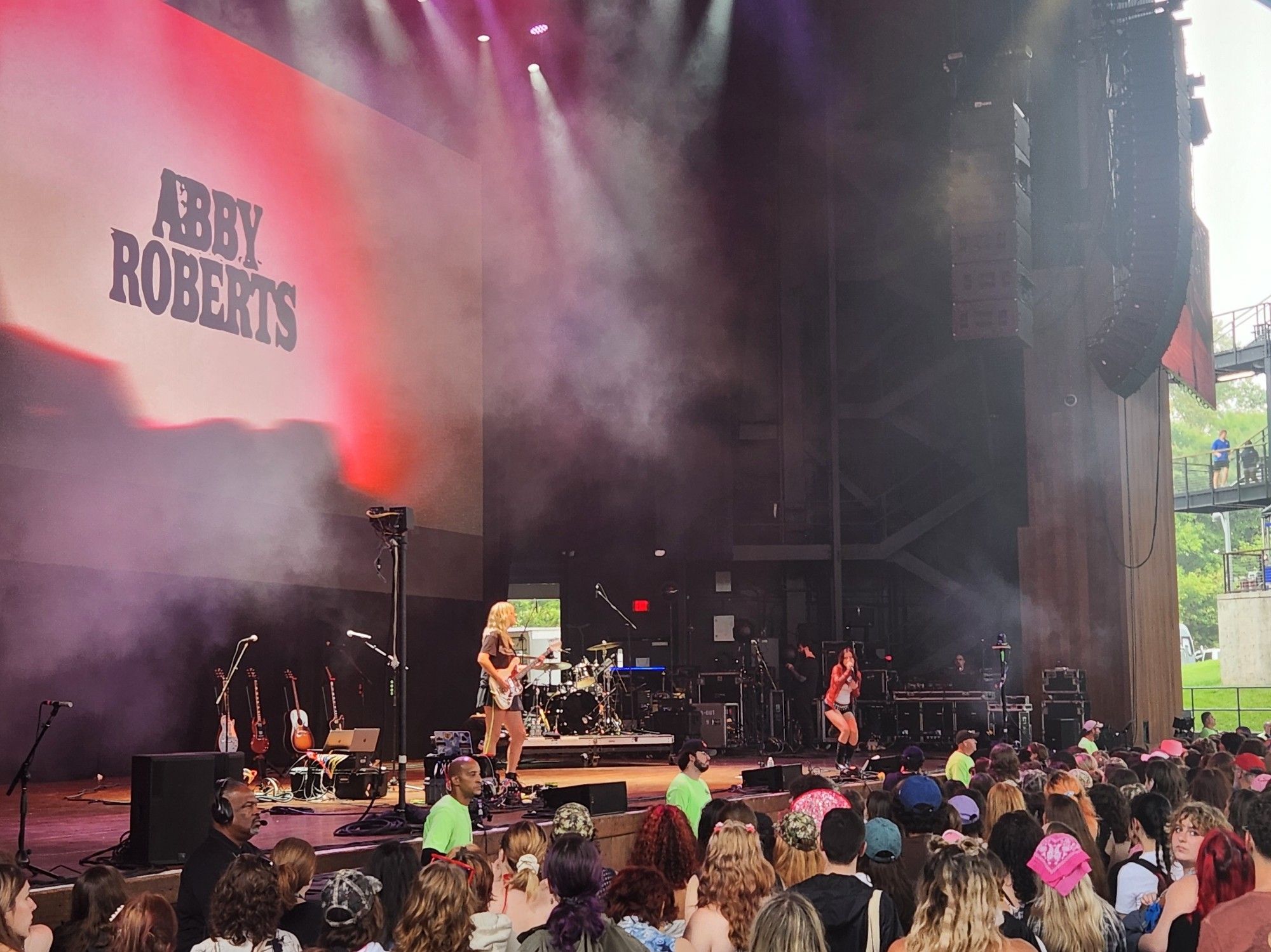 Music band Abby Roberts performing on stage in front of crowd.