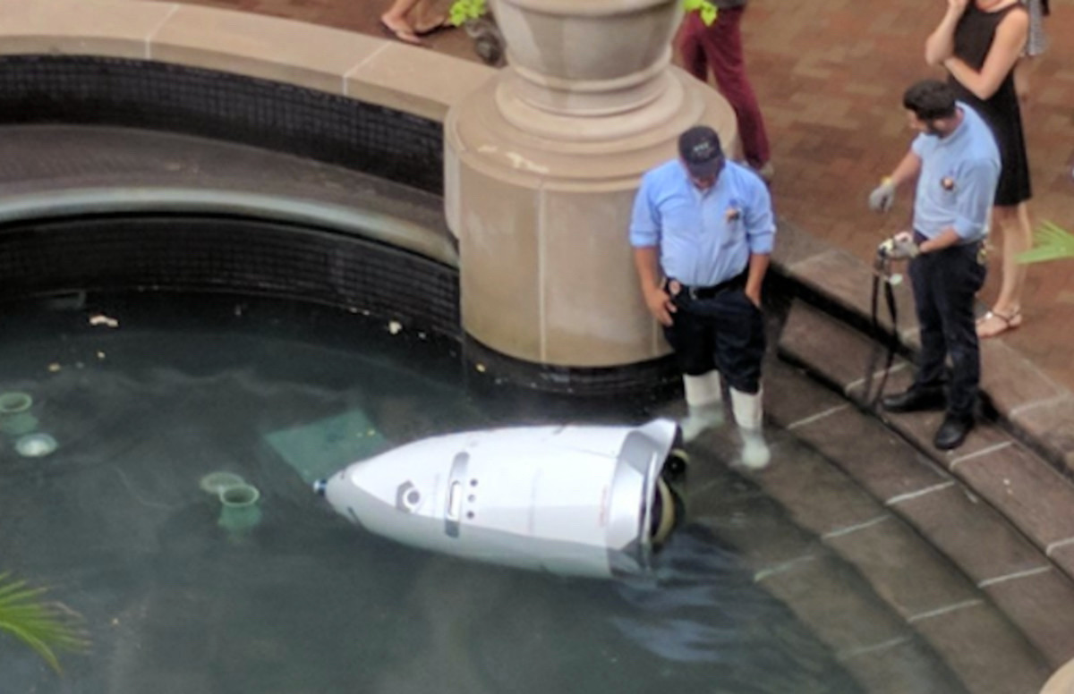 Mall cop robot that's fallen into a water feature