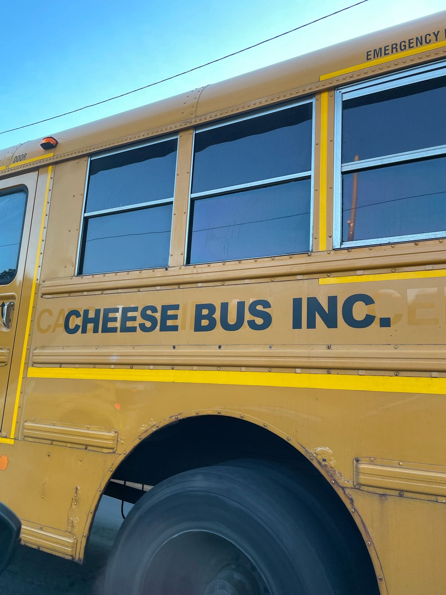 The side of a school bus. It used to be for a school district and now it’s labeled “cheese bus inc.”