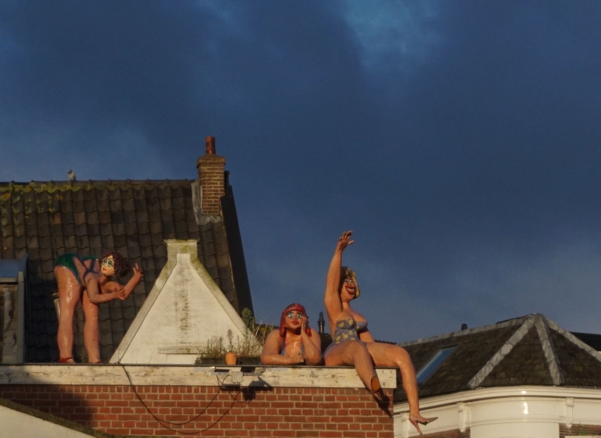 3 vrouwen in bikini op een dak. 