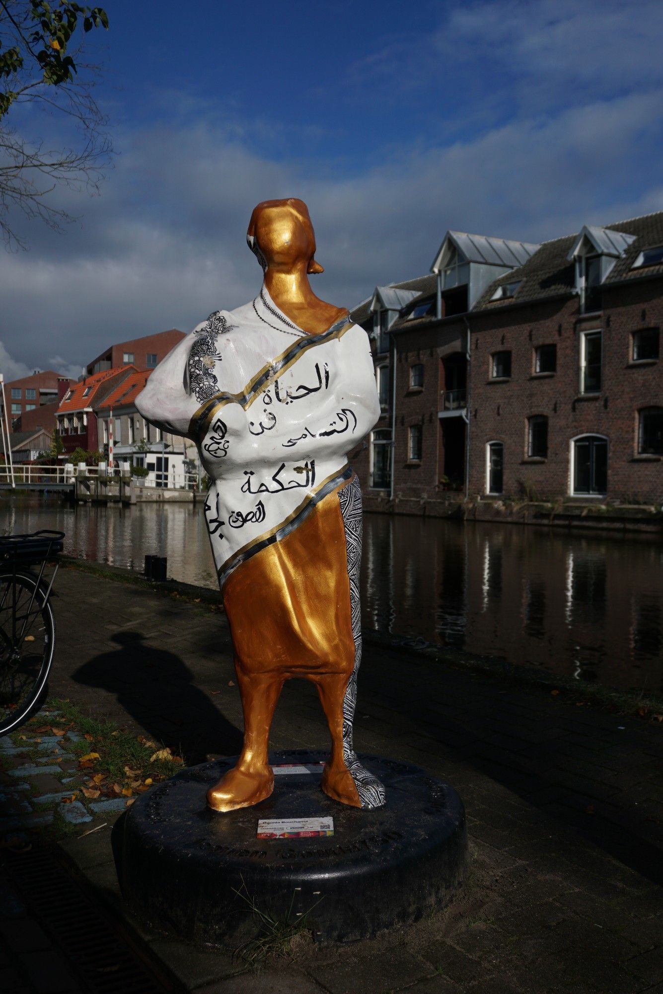 Een kaasmeisje. Goud met witte jurk met Arabische tekst erop