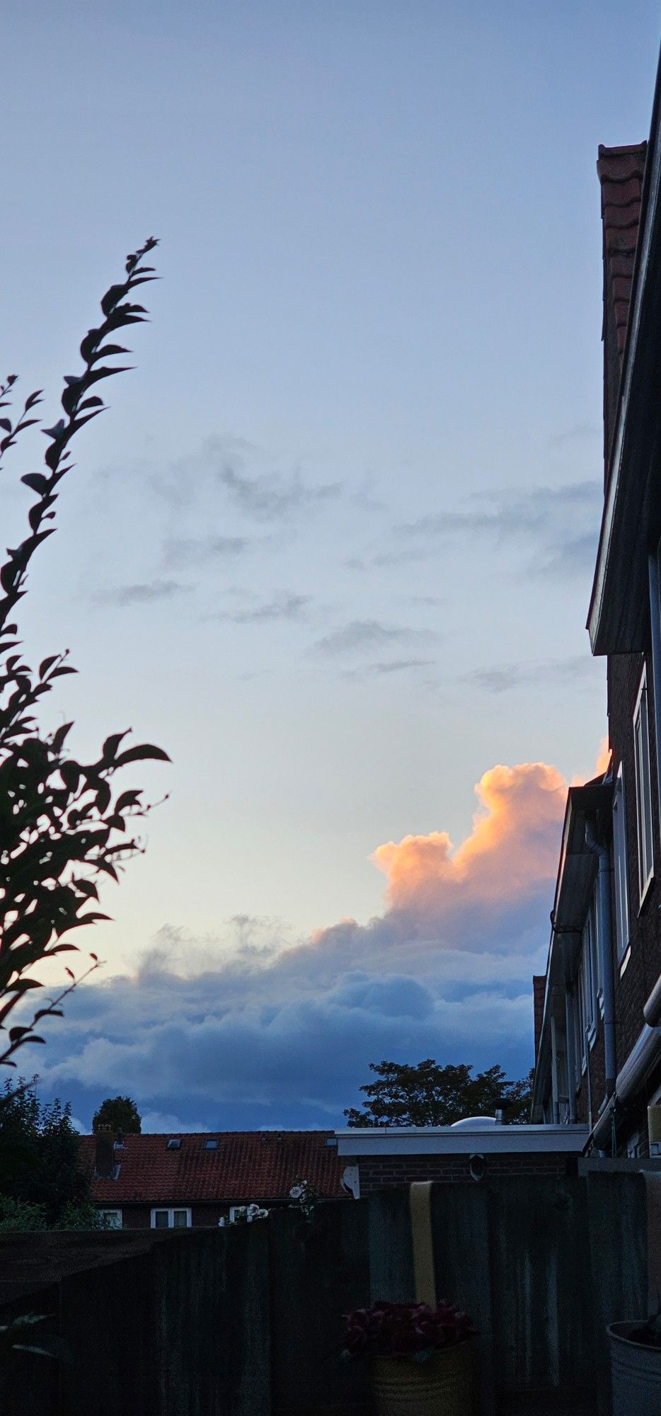 Blauwe lucht met oranje gekleurde wolk