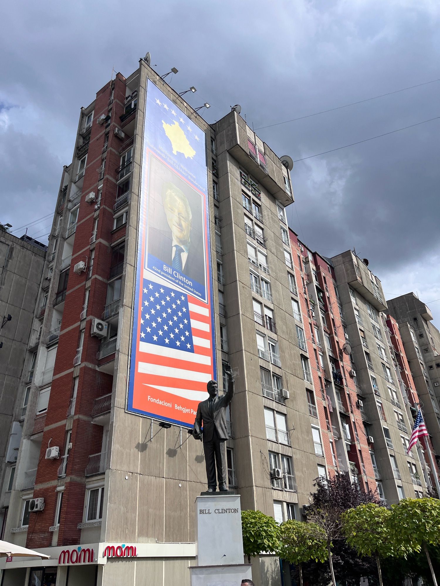 A statue of Bill Clinton in front of a giant Bill Clinton poster in Pristina, Kosovo