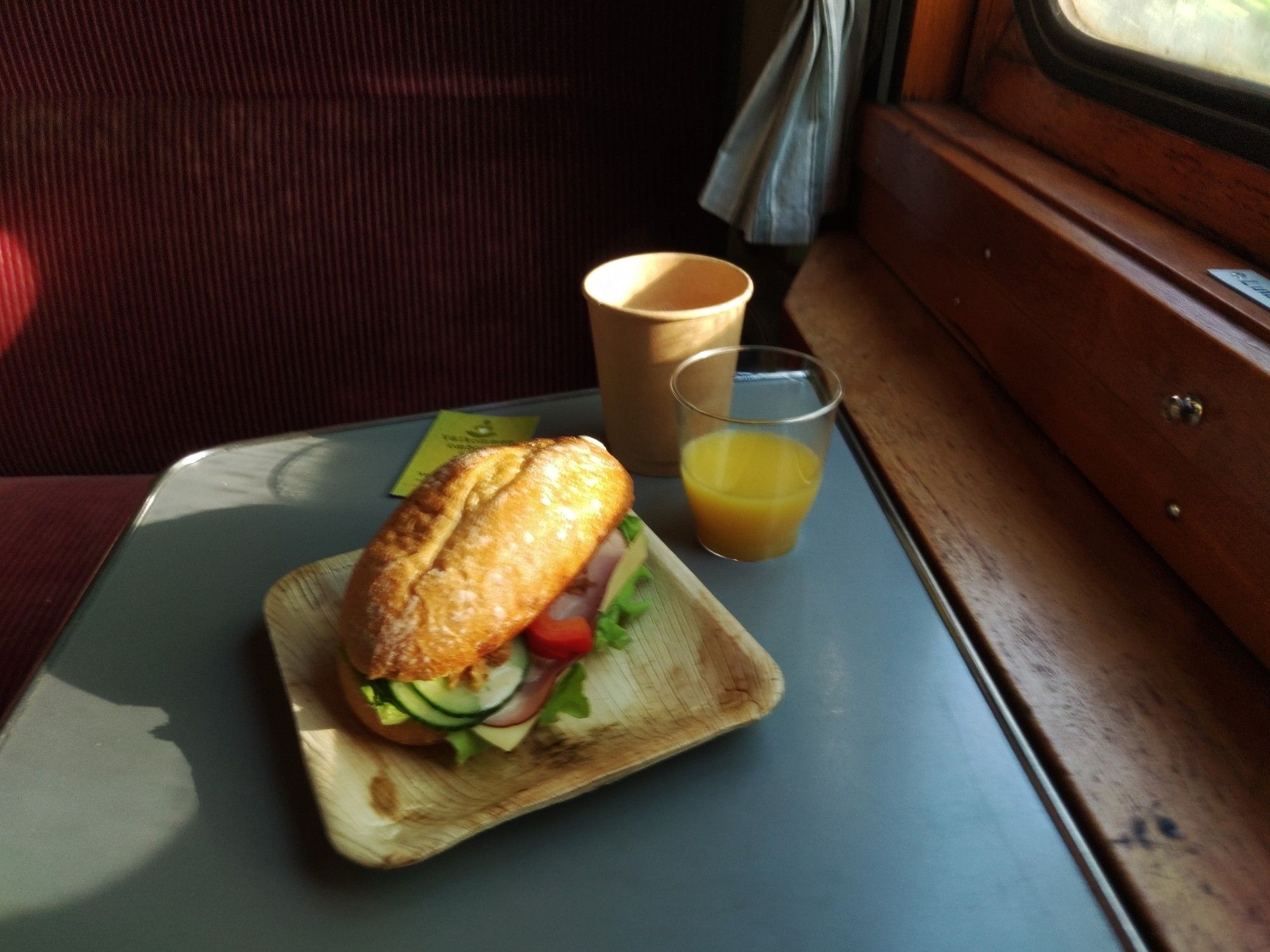 Ein belegtes Brötchen, Kaffee und Orangensaft im Zug.