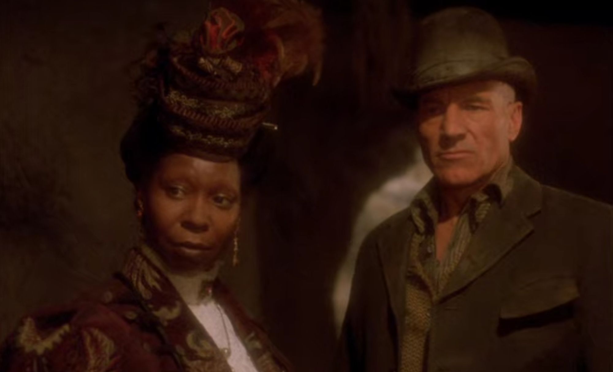 Guinan and Picard in old Victorian clothing in a cave.