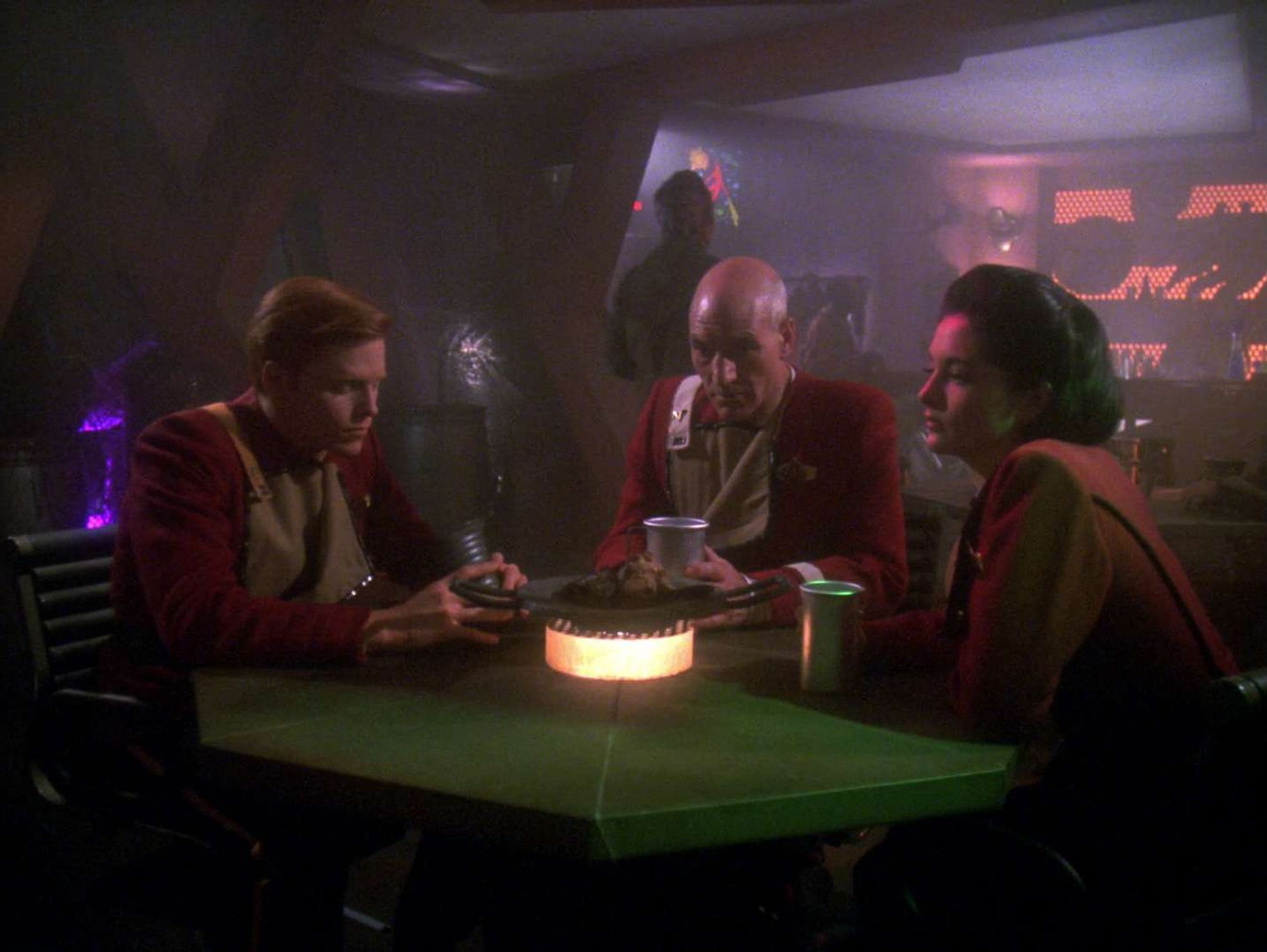 Picard with his two Academy friends in a darklit bar.