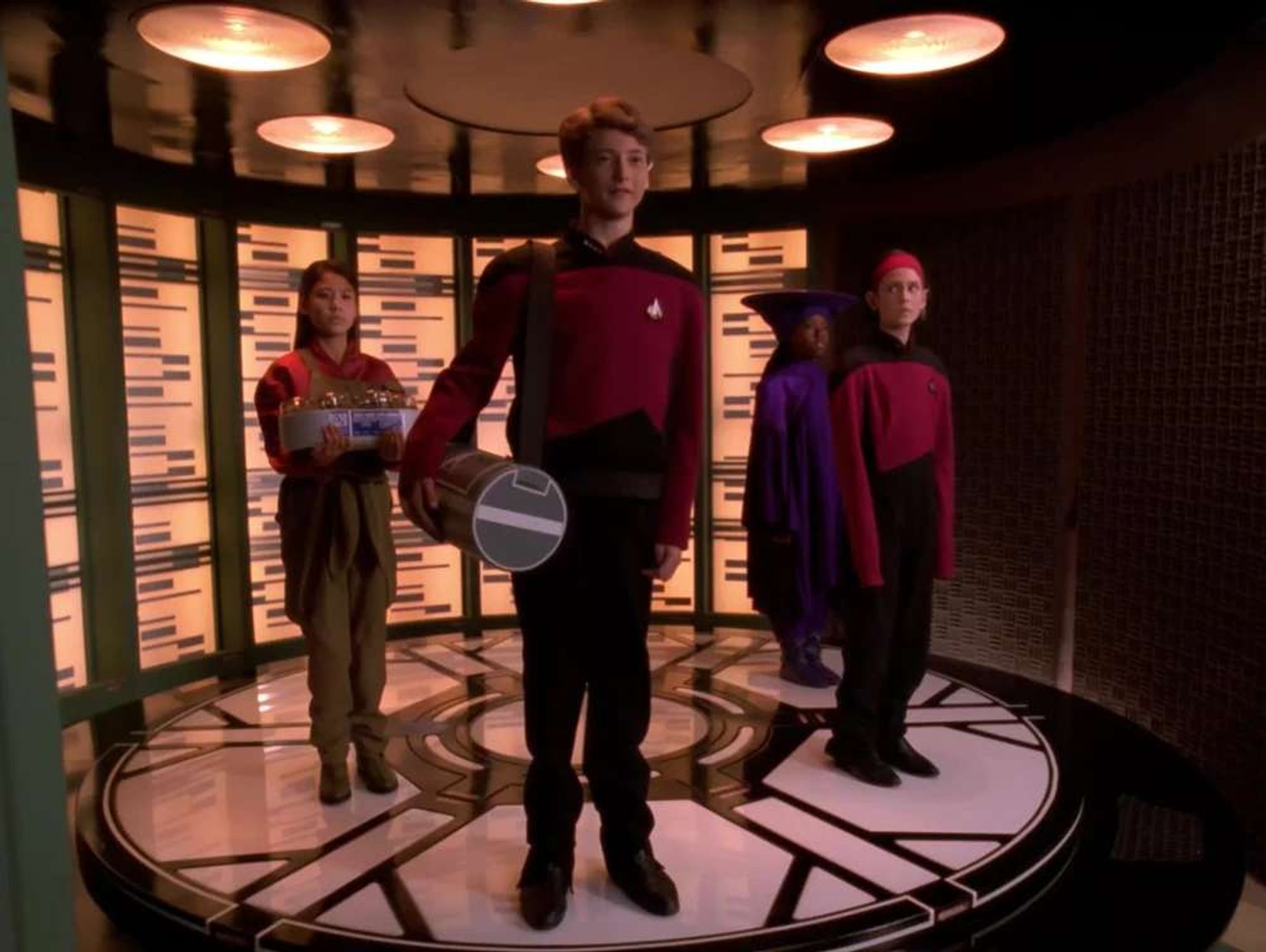 Keiko, Picard, Guinan and Ro, young on the transporter pad. (Why did some clothes shrink while Ro's uniform didn't???)