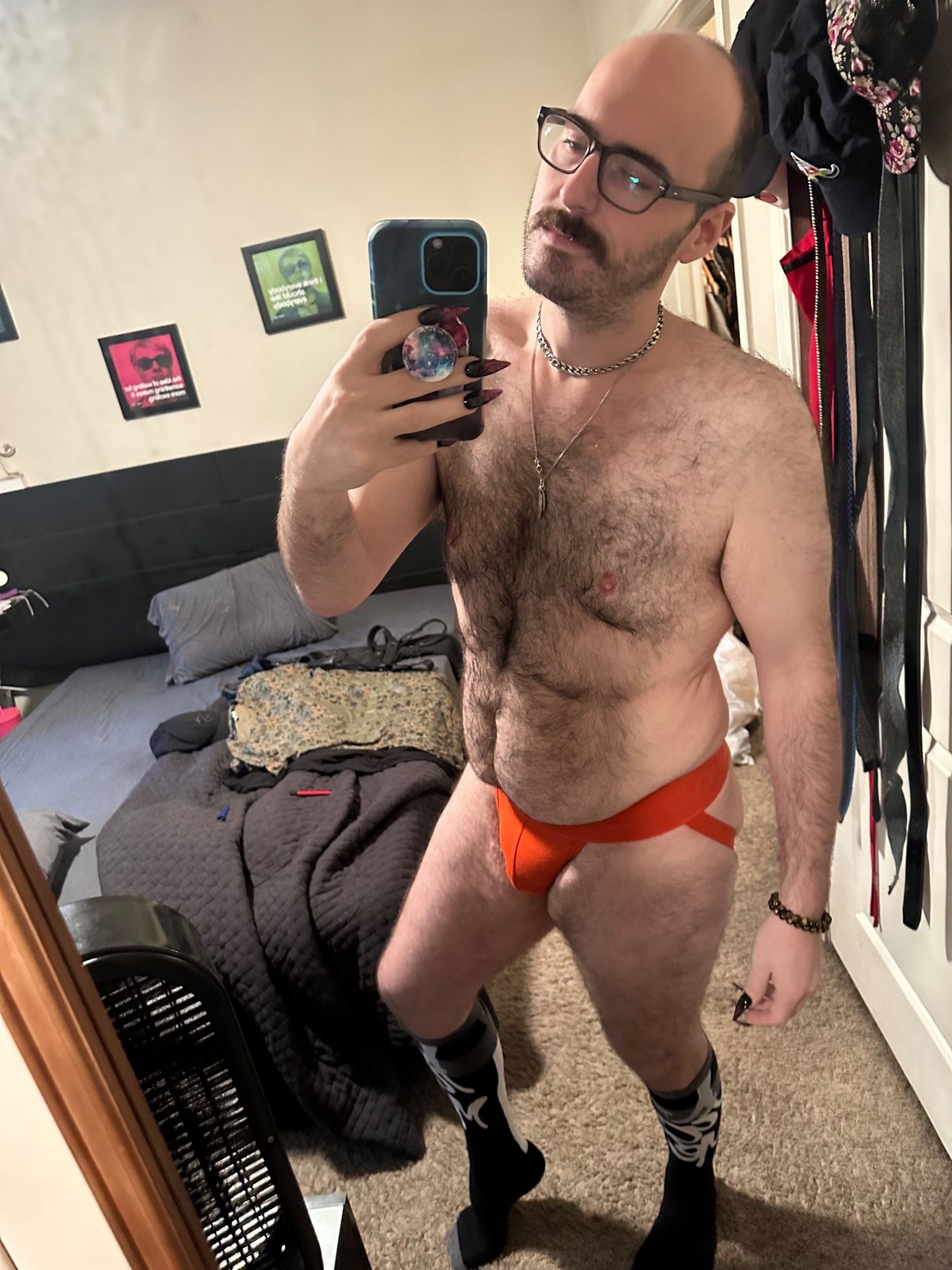 Me standing in front of my mirror wearing silver choker and necklace, orange Savage Fenty Jock, and black “fuck me” socks from Frot troff.