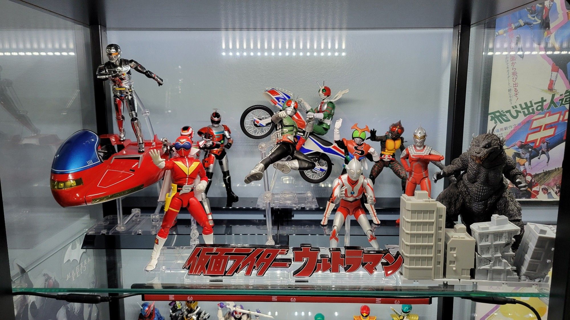 Groupshot of figuarts Gavan upon the Saibarian; Juspion; Winspector Fire; Kamen Rider V3 upon the Hurricane; Seihou Amazon; Stronger; Ultra Seven; GMK Godzilla and damaged buildings; Ultraman; Ultraman logo acrylic stand; Seihou Ichigo kicking mid air; Kamen Rider Logo; Akarenger