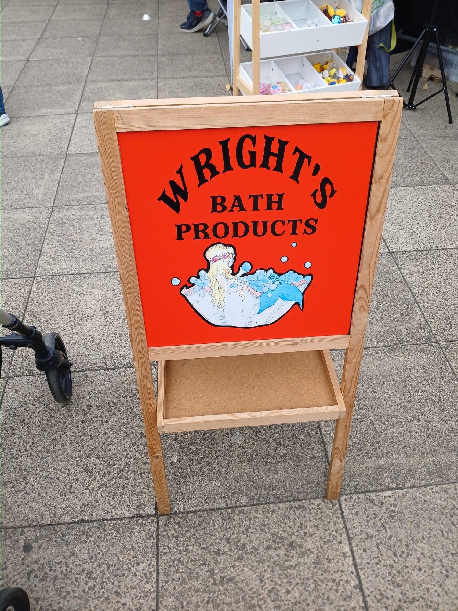 It is a bright red A Board sign saying Wright's Bath Products with a mermaid in a bath illustration.