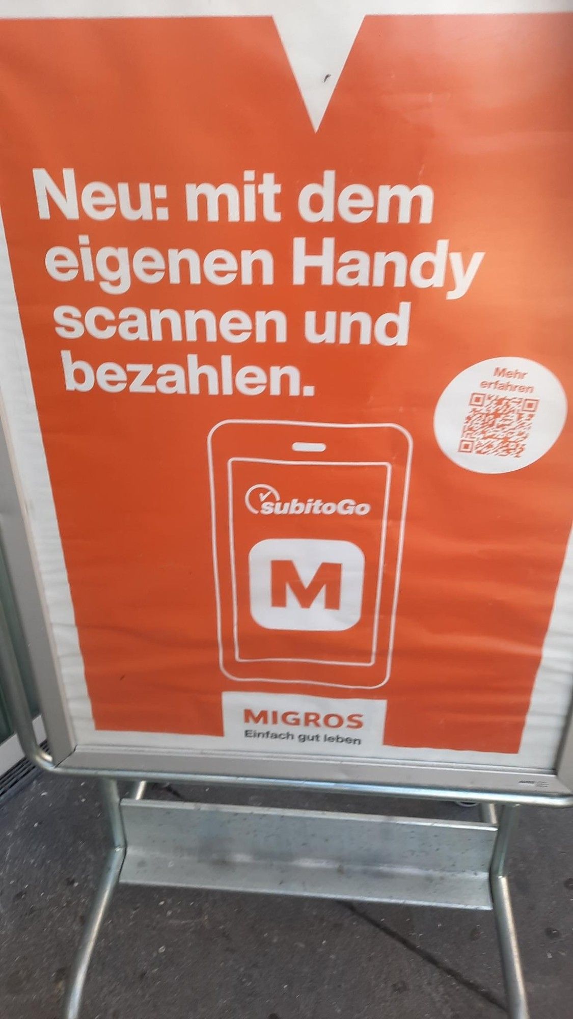 Migros-Plakat: "Neu: mit dem eigenen Handy scannen und bezahlen."