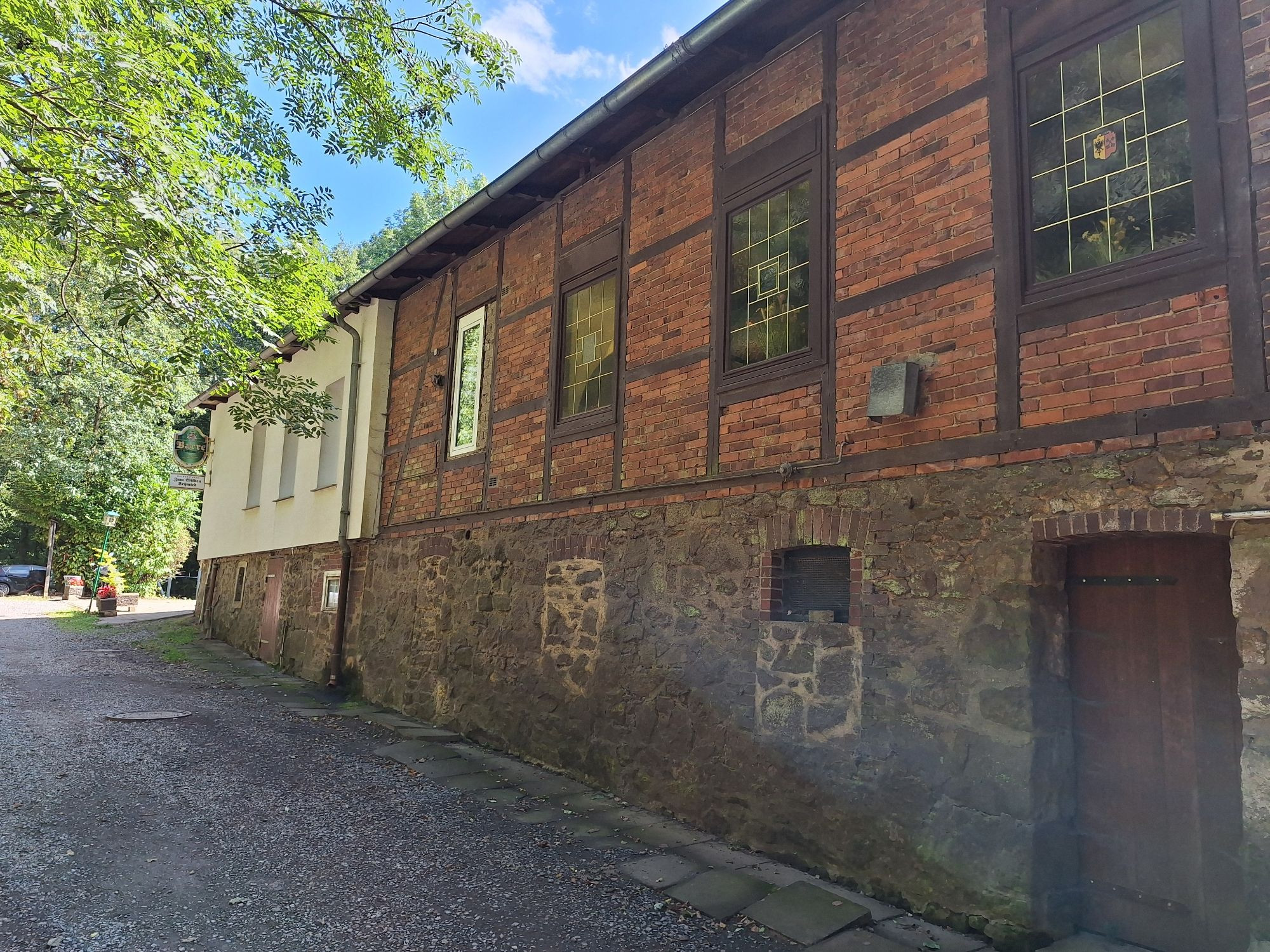 Ein langgestrecktes Gebäude, zum Teil aus Bruchstein und Fachwerk mit Gefache aus rotem Klinker. Das Gebäude ist das Restaurant, wo wir heute Abend einkehren.