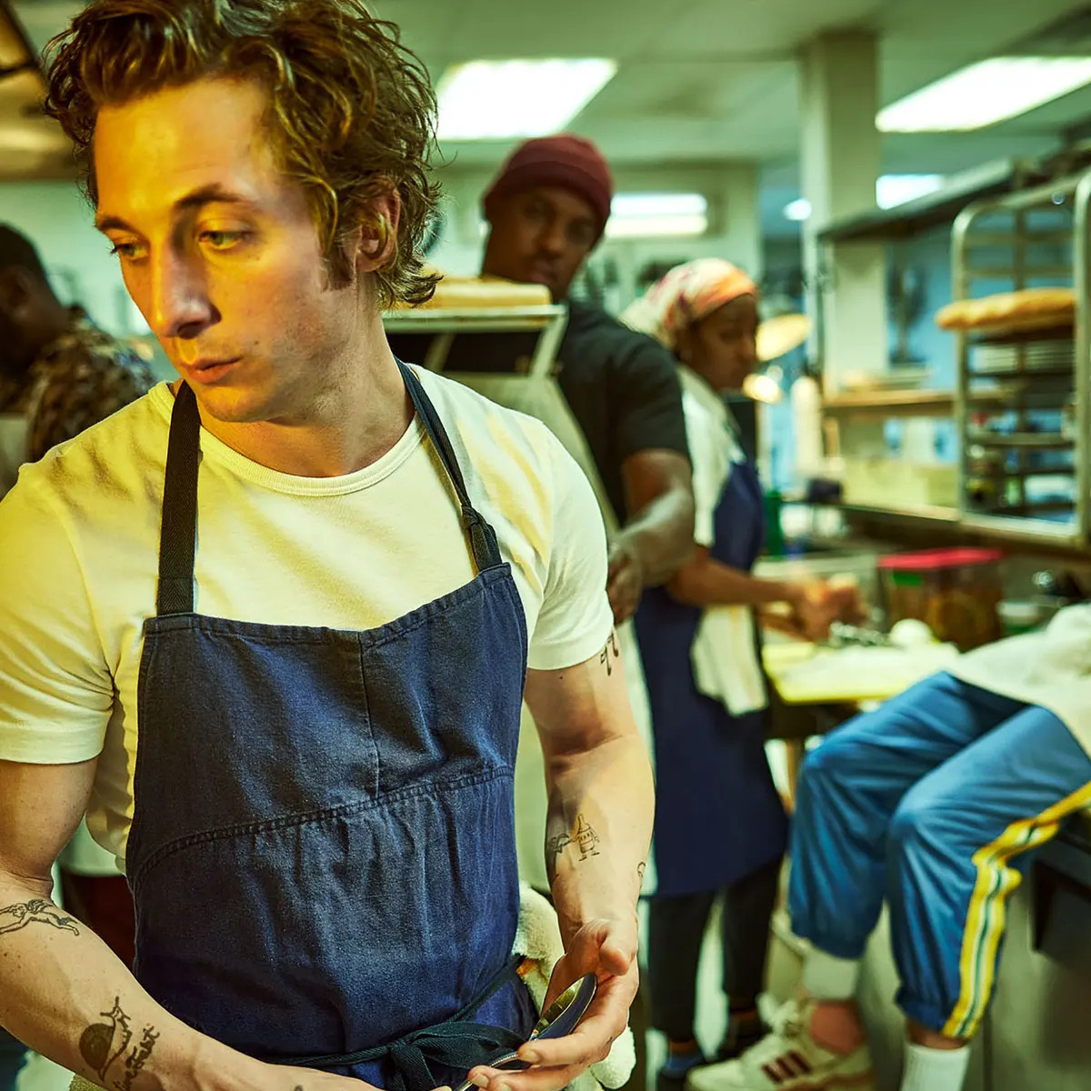 A promo shot of The Bear where Carmen looks really cool while cooking