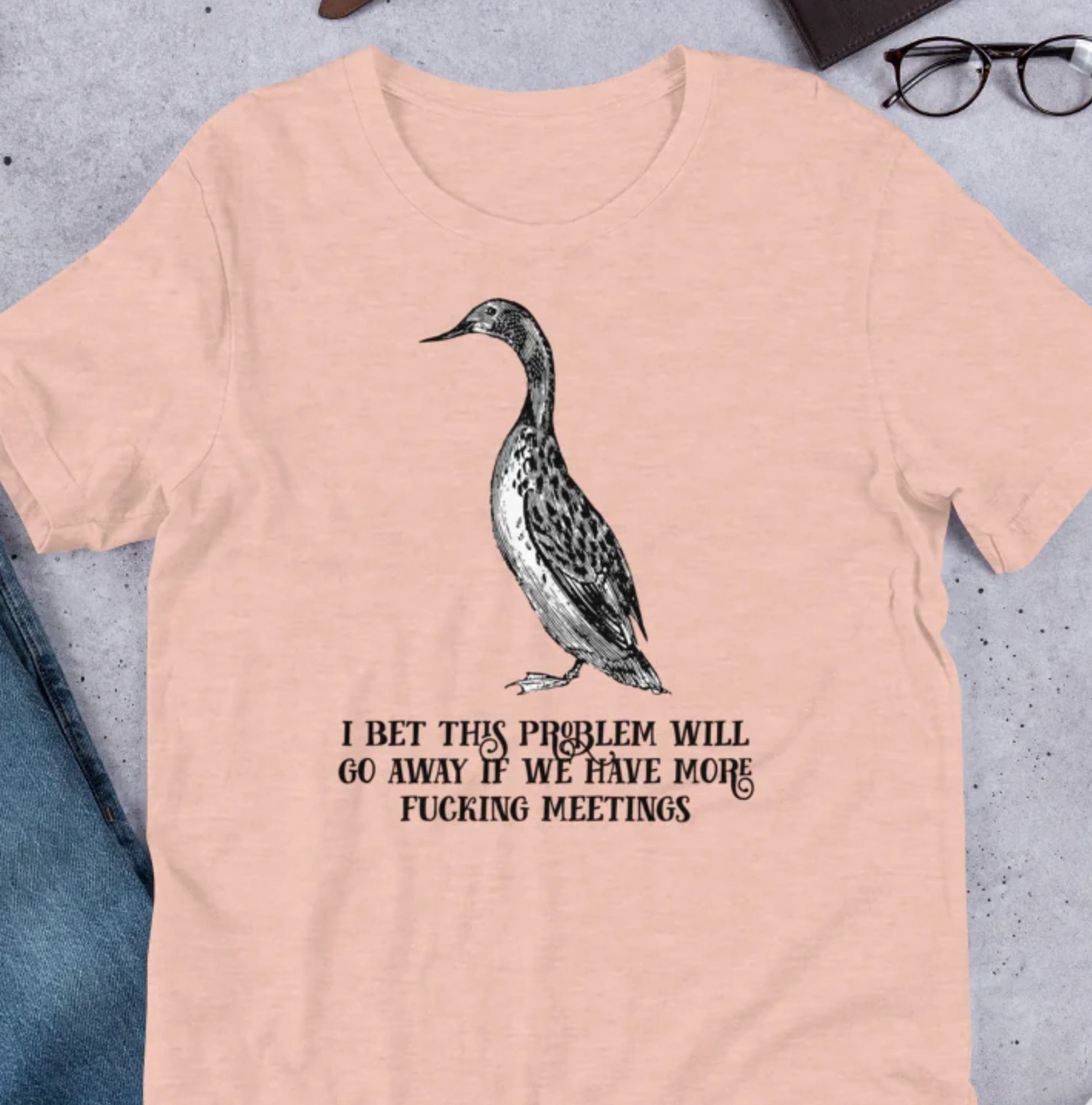 T-Shirt mit einem Vogelportrait, darunter steht der Satz: »I bet this problem will go away if we have more fucking meetings«.