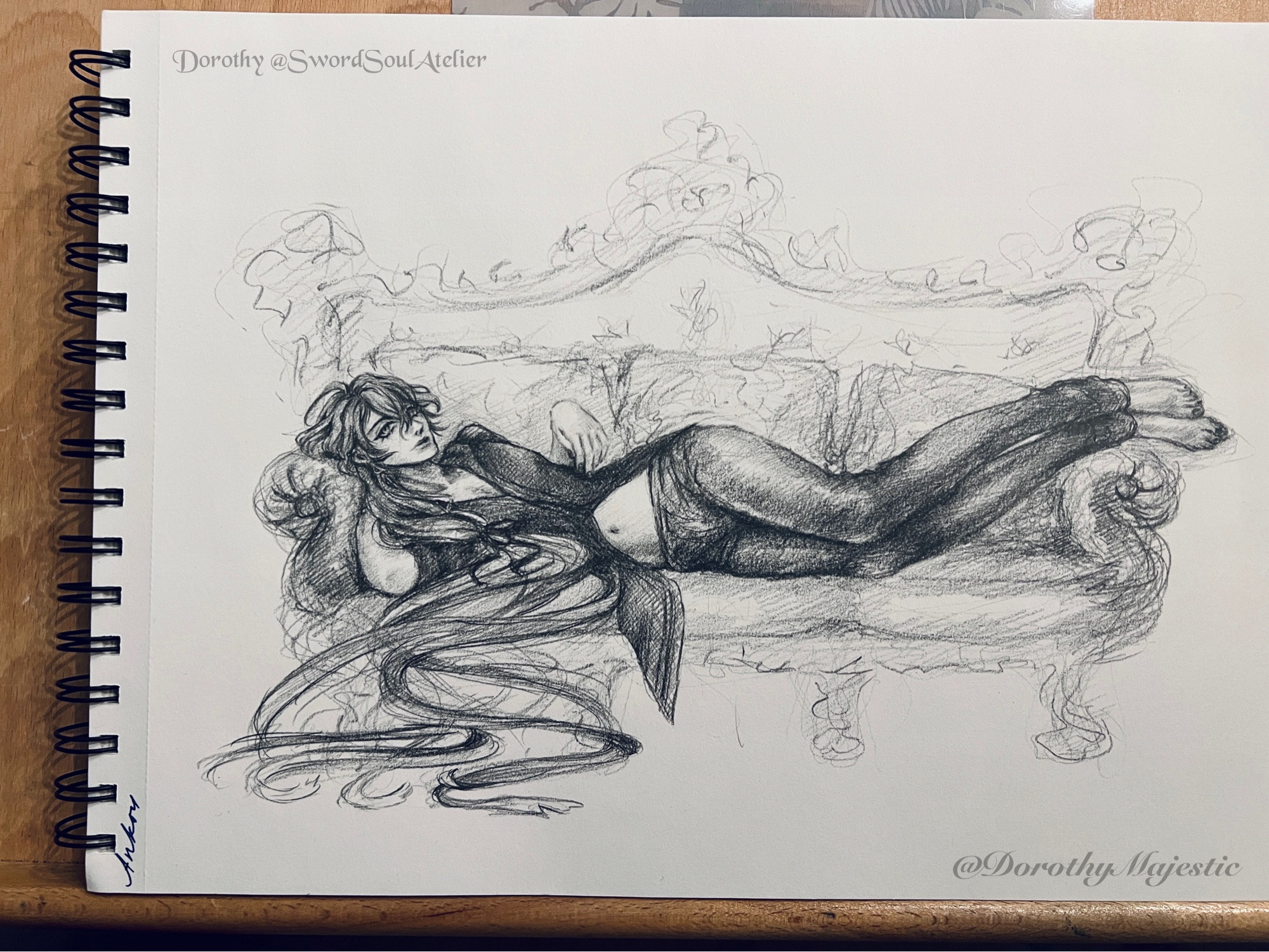 Graphite drawing on whit paper. Ankou laying down on a fancy couch. Wearing a sheer black tunic style shirt with a few buttons done across the torso, & dark maroon pants. Stomach, cleavage, & clavicle exposed. Bare feet resting on one side of the couch. Hair loosely tied in a side ponytail, and flowing onto the floor.