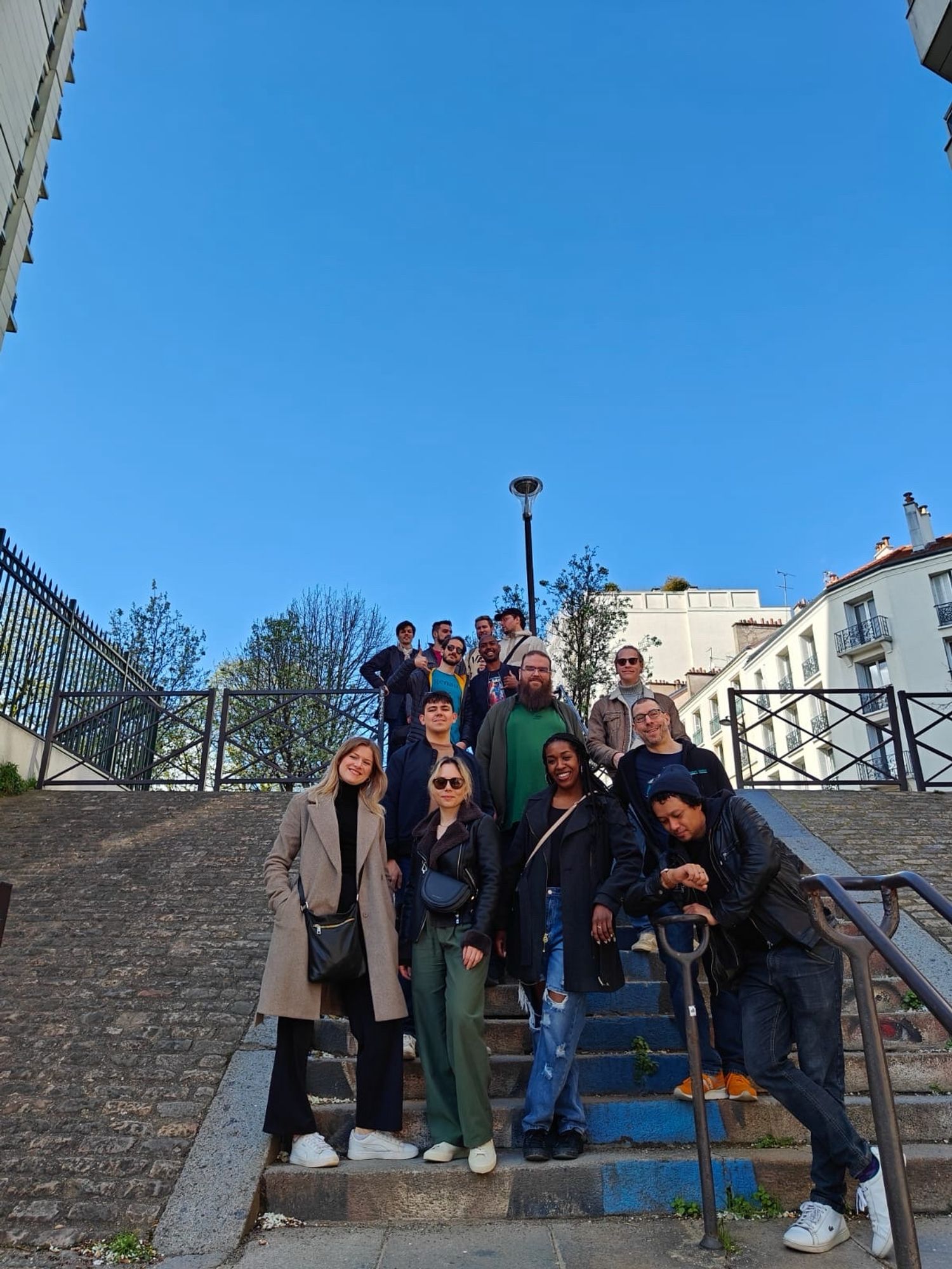 Group of speakers from React Paris posing on the stairs