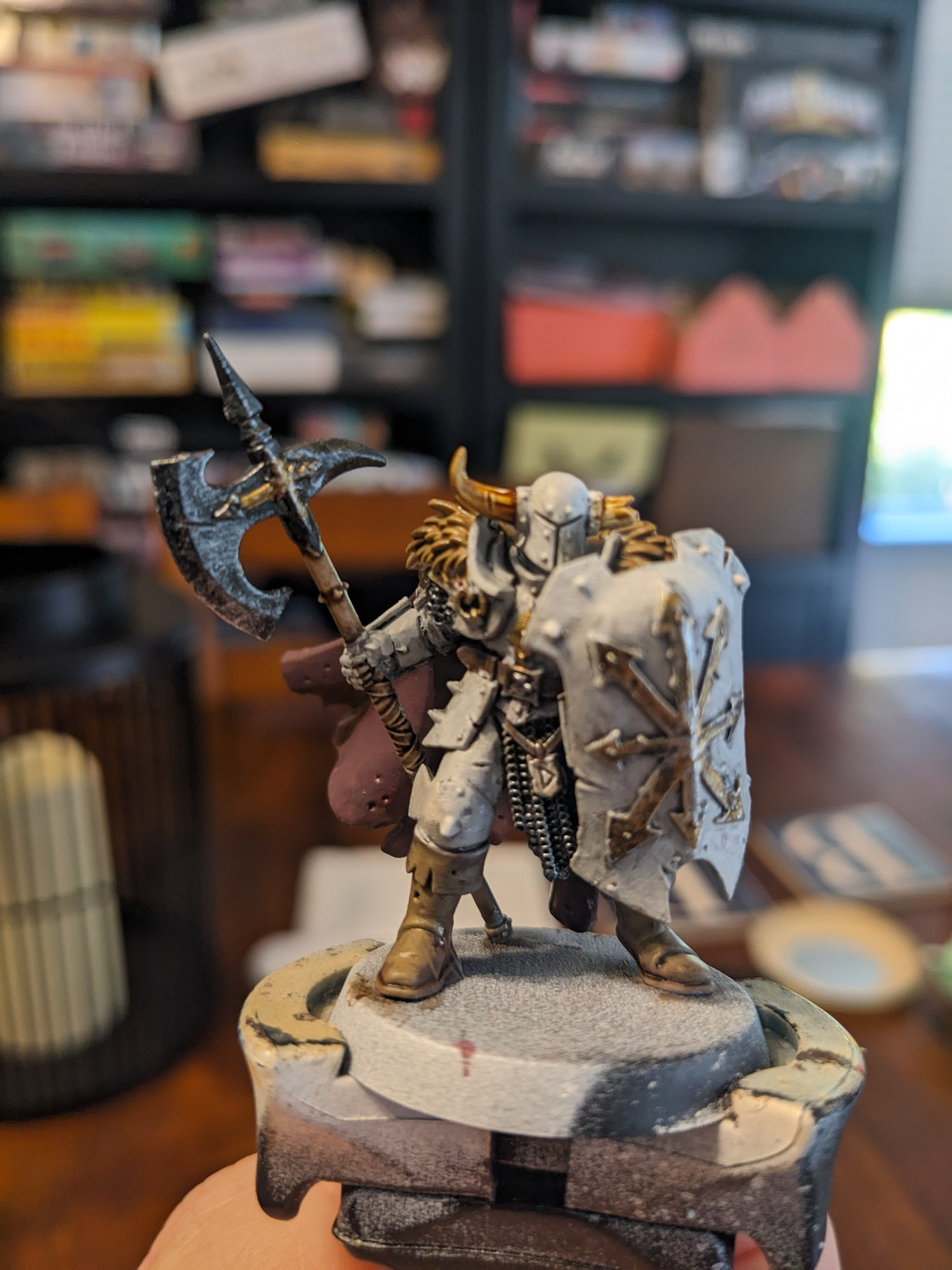 An Age of Sigmar Slaves to Darkness model with shield and halberd wearing white armor and a dark purple cape. Front view.