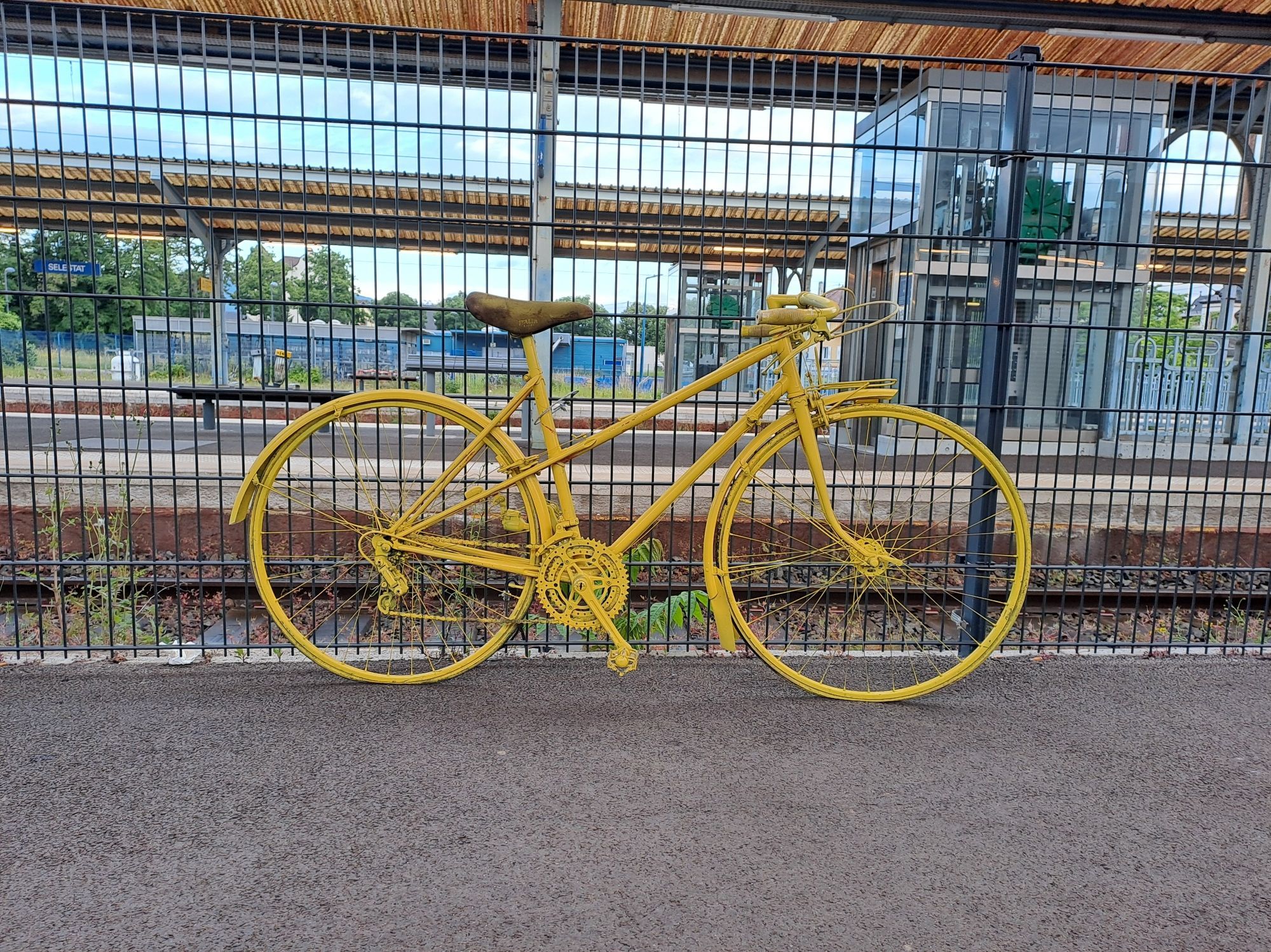 Vélo jaune sur le quai de la gare