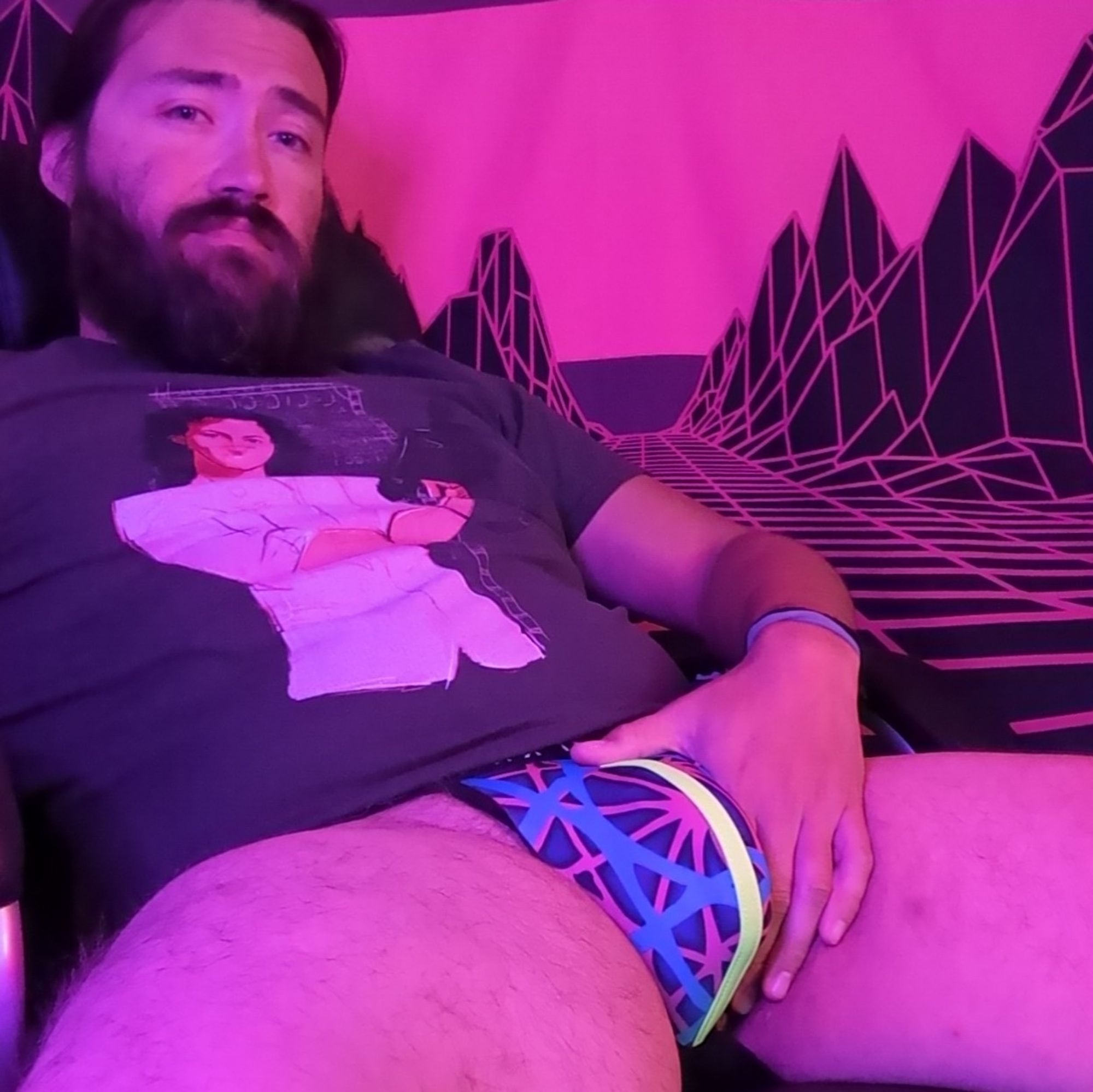 Austin sitting grabbing his bulge wearing colorful jock